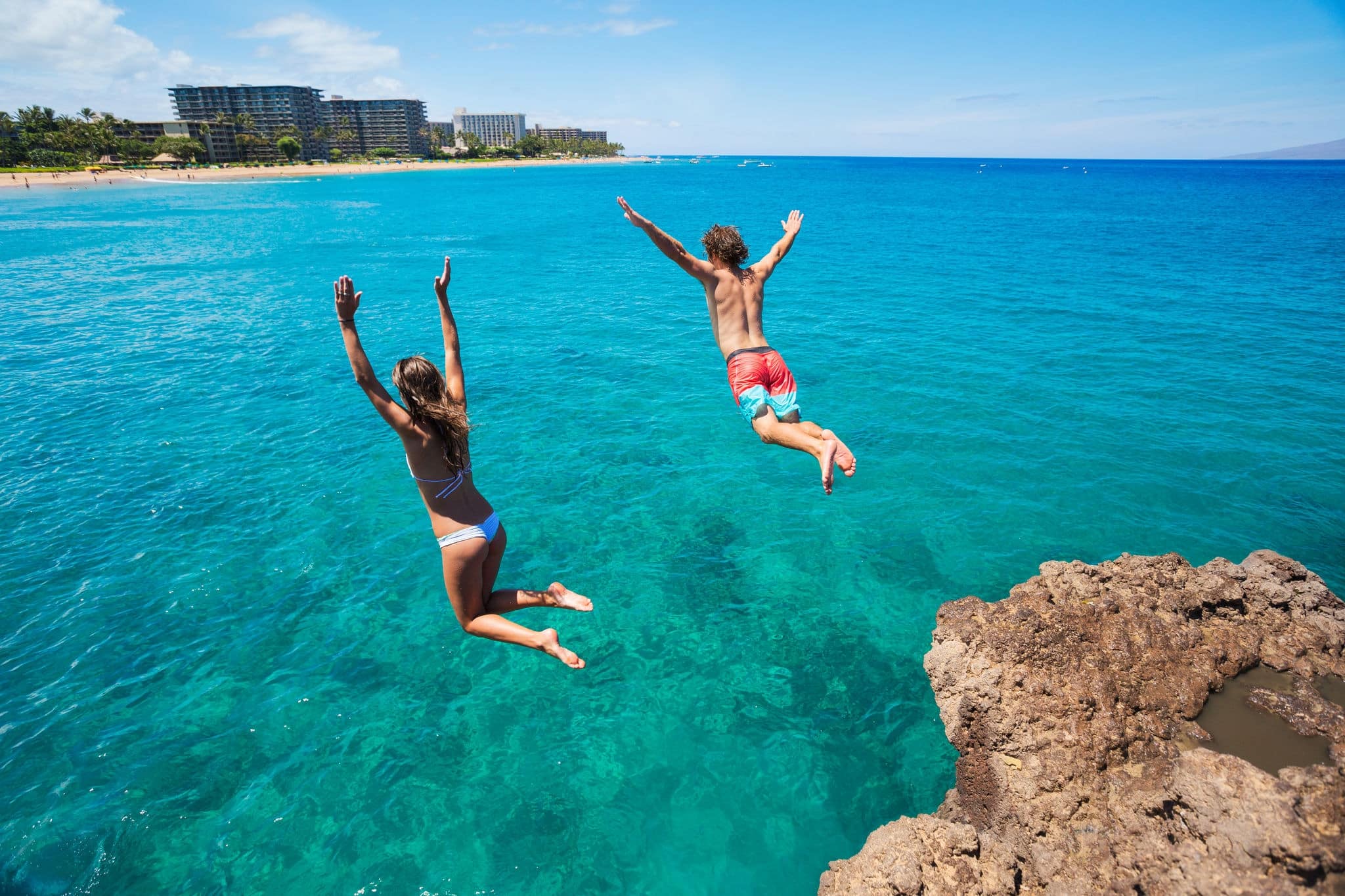 Summer fun, Friends cliff jumping into the ocean. 