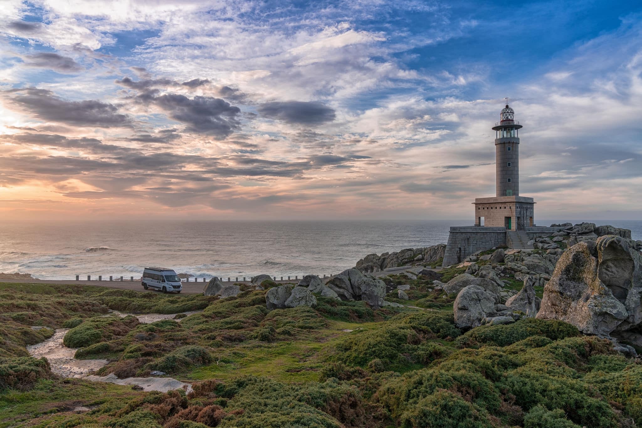 Malpica, Galicia - Spain - 26 November 2020: sunset at the Punta Nariga lighthouse in Galicia with a gray camper van parked there