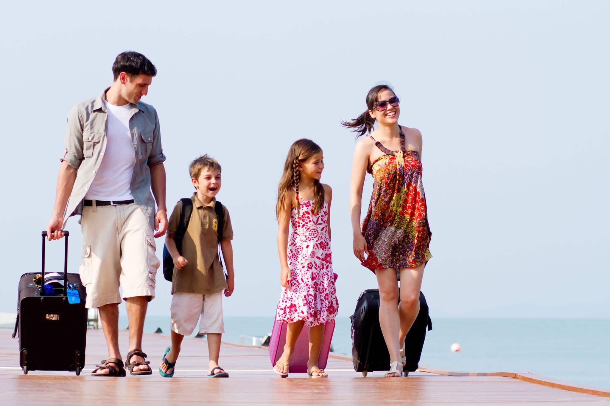 A family of 4 arriving at the resort with their luggage.