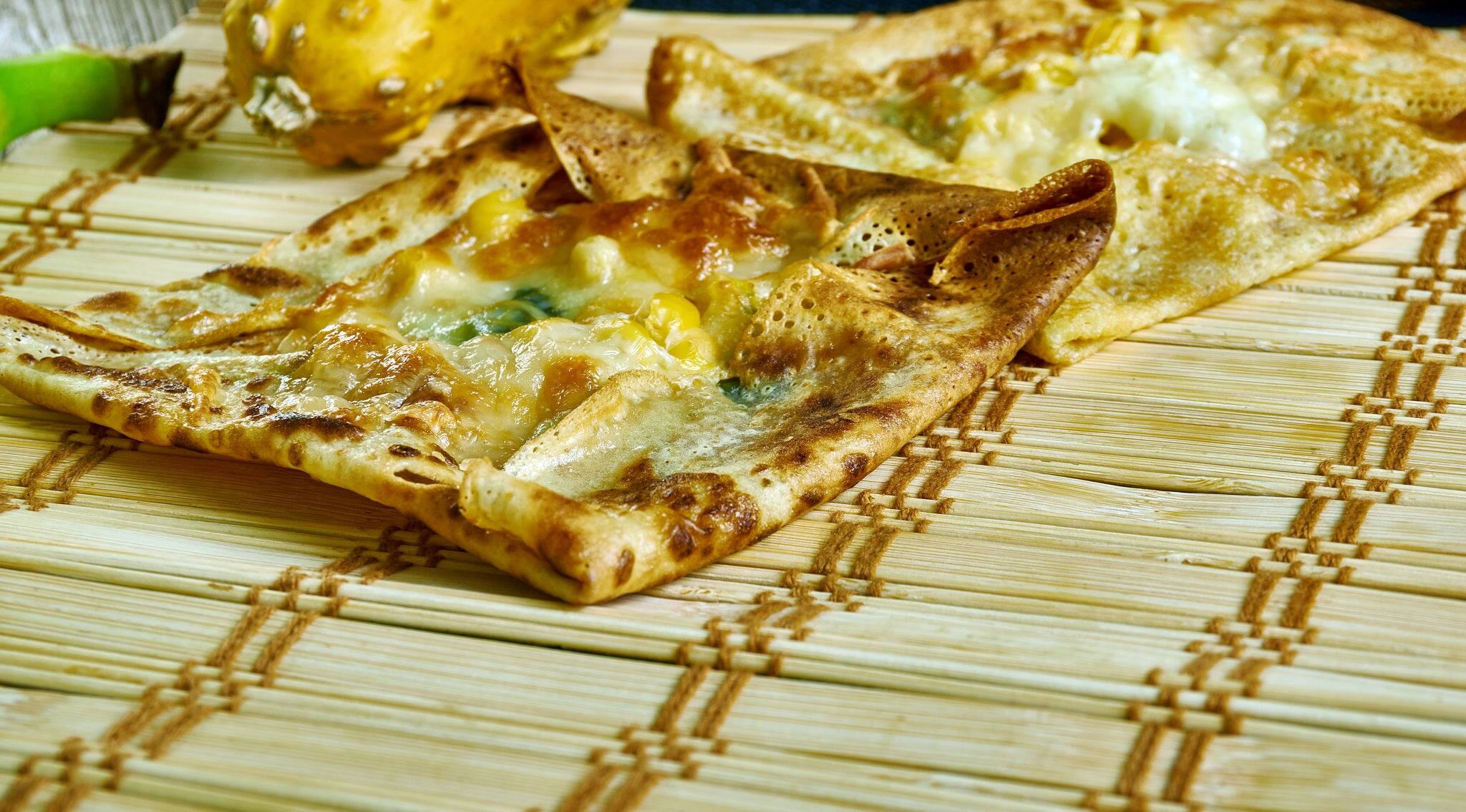 Zanzibar pizza, crispy pancakes with as many meats, sweets, or vegetables , Tanzanian cuisine, Traditional assorted African dishes, Top view.