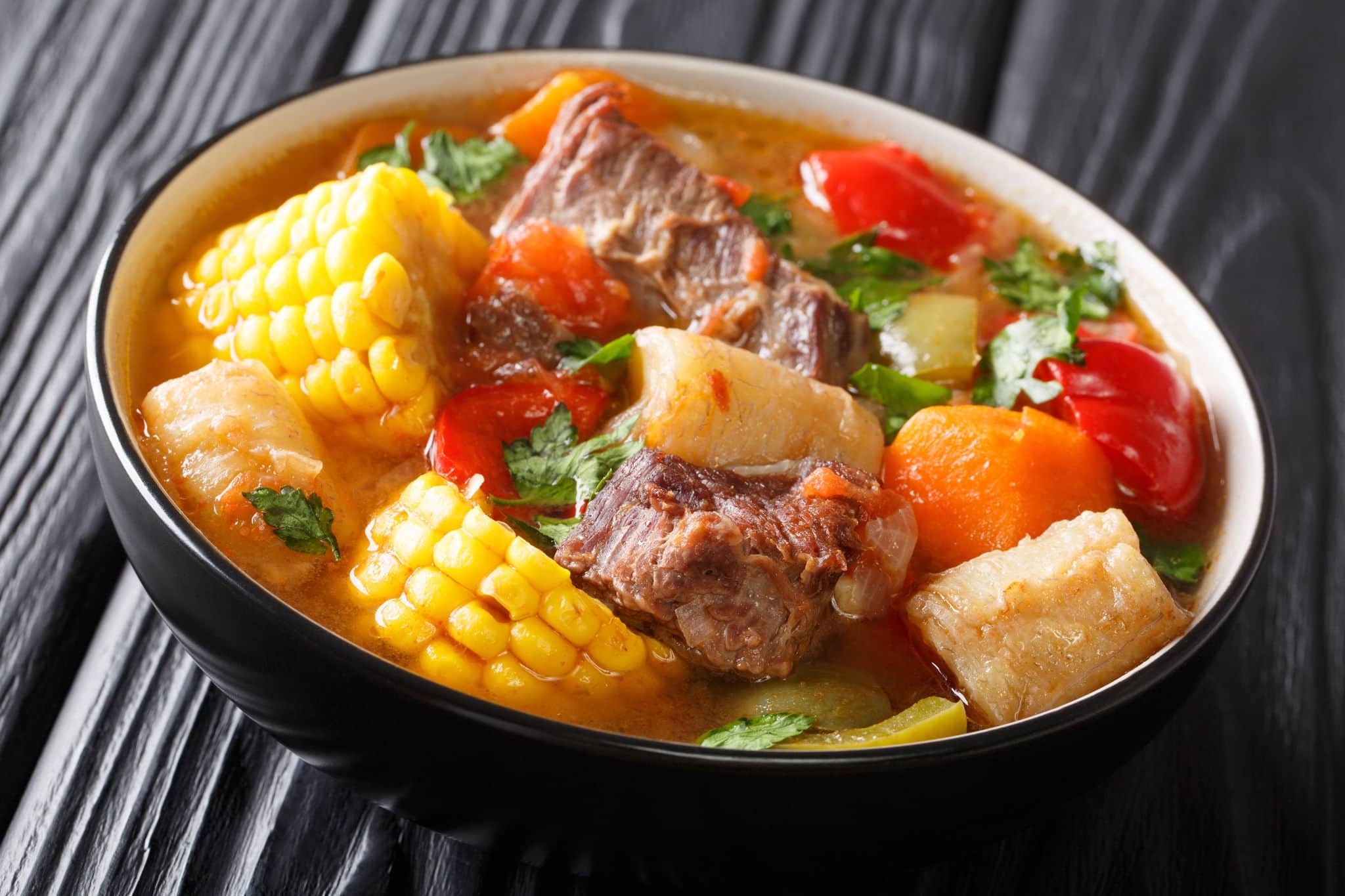 Delicious Sancocho thick meat soup with vegetables close-up in a bowl on the table. horizontal