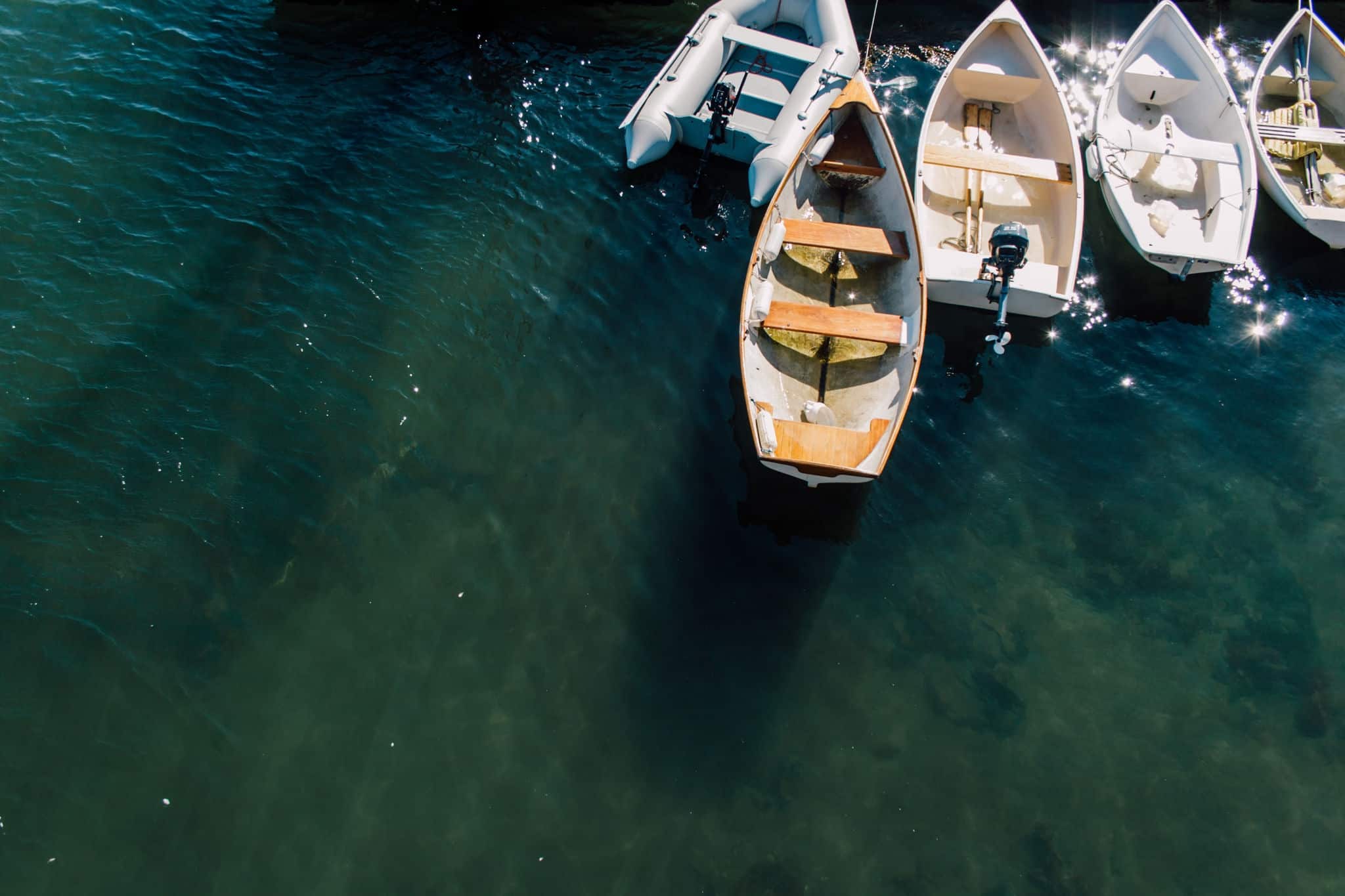 A collection of boats dock in clear water in Rockland, Maine