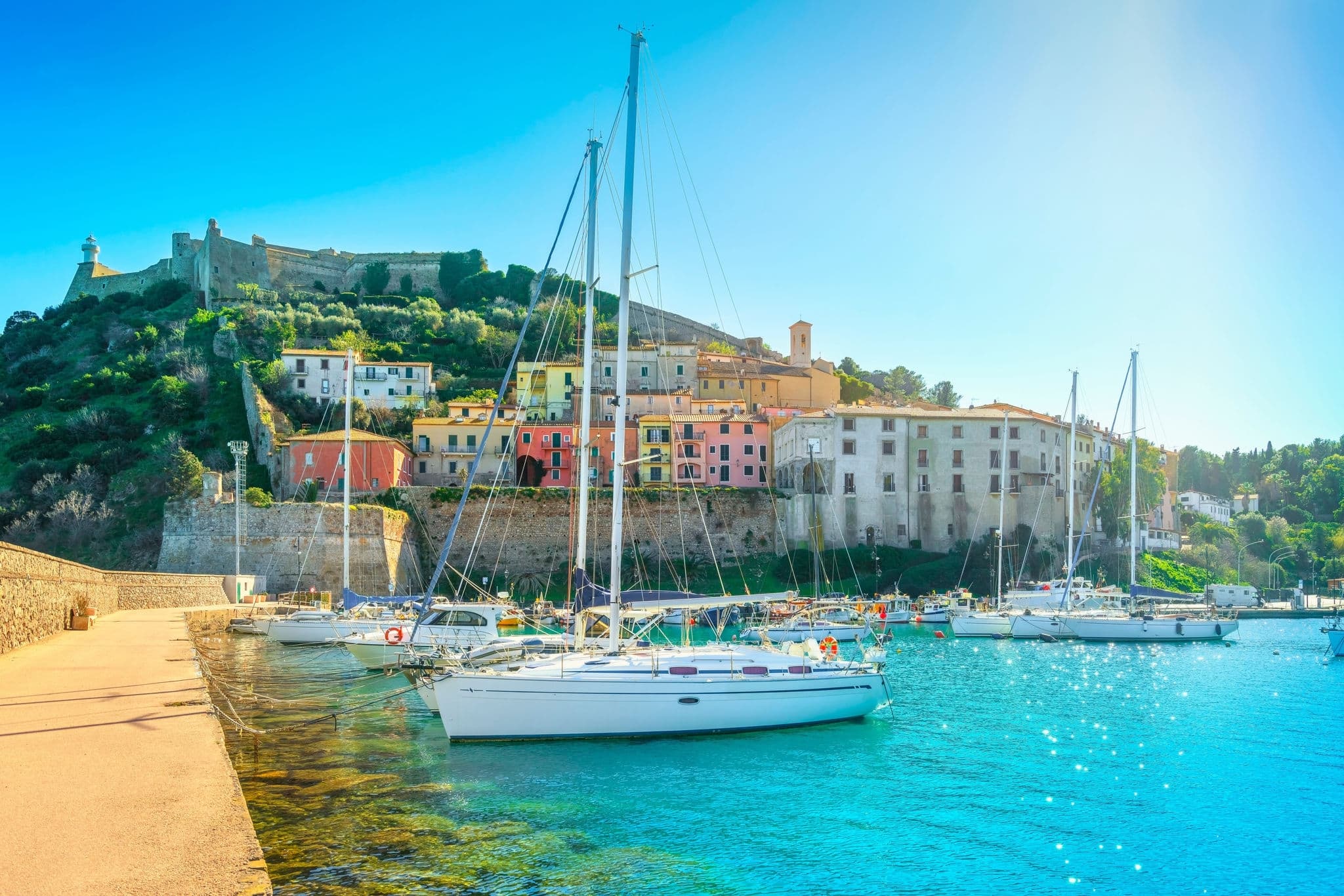 Porto Ercole village and boats in the harbour. Fortress in the background. Monte Argentario, Maremma, province of Grosseto, Tuscany region, Italy
