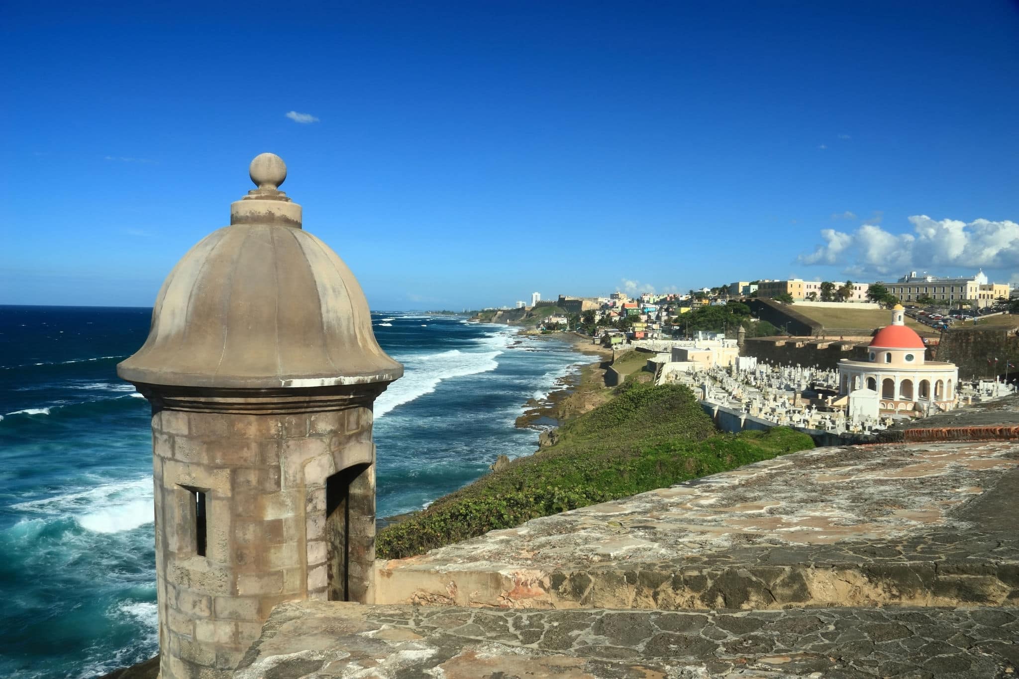 Sentry box overlooking the Atlantic Ocean at 'El Morro' (Castillo San Felipe del Morro) and the La Perla district of Old San Juan, Puerto Rico, including an old cemetery