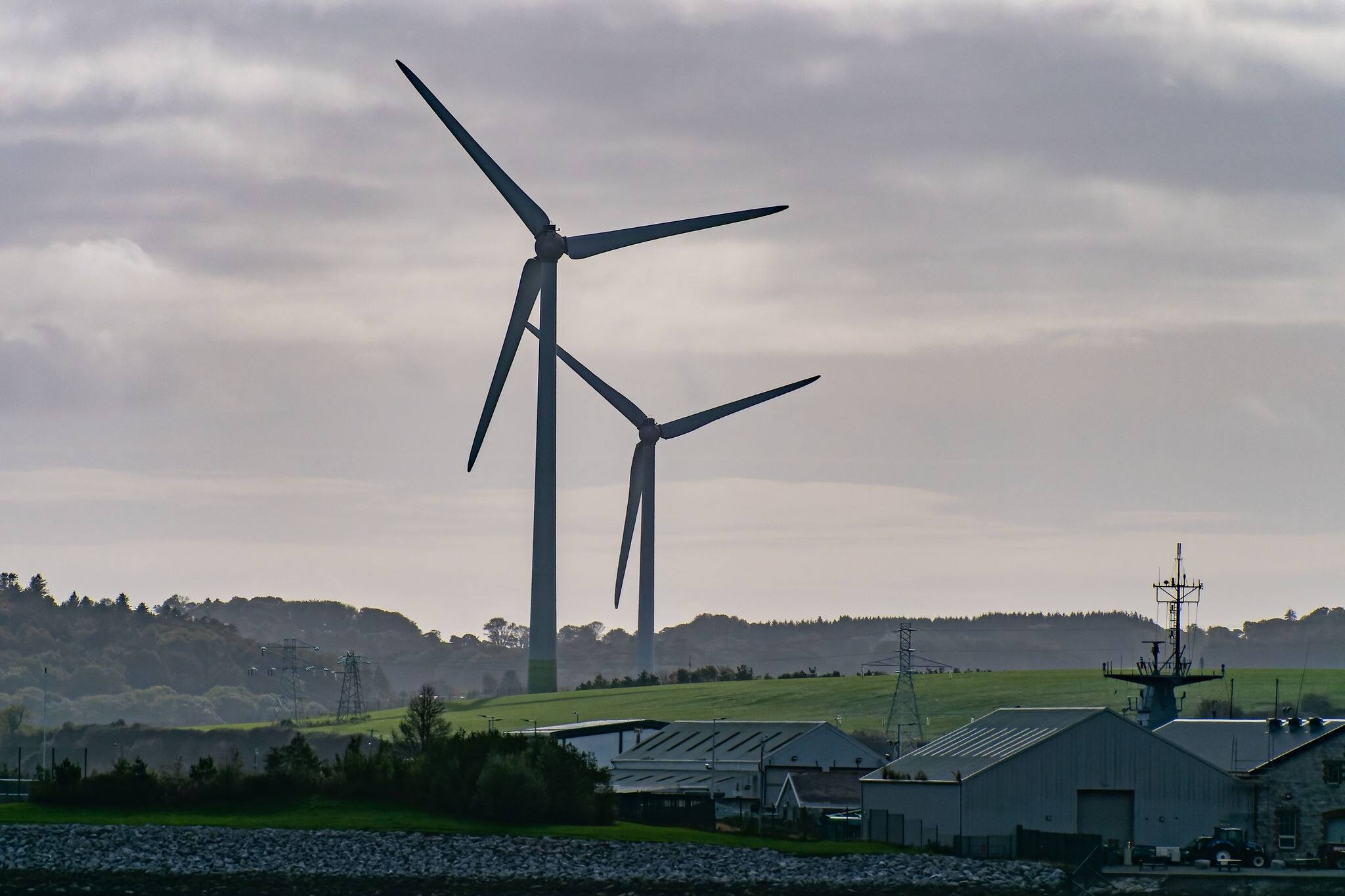 Wind power generators in the south of Ireland, landscape. Two wind turbines located in Ringaskiddy, County Cork. Cloudy overcast sky. wind turbine under white cloudy sky