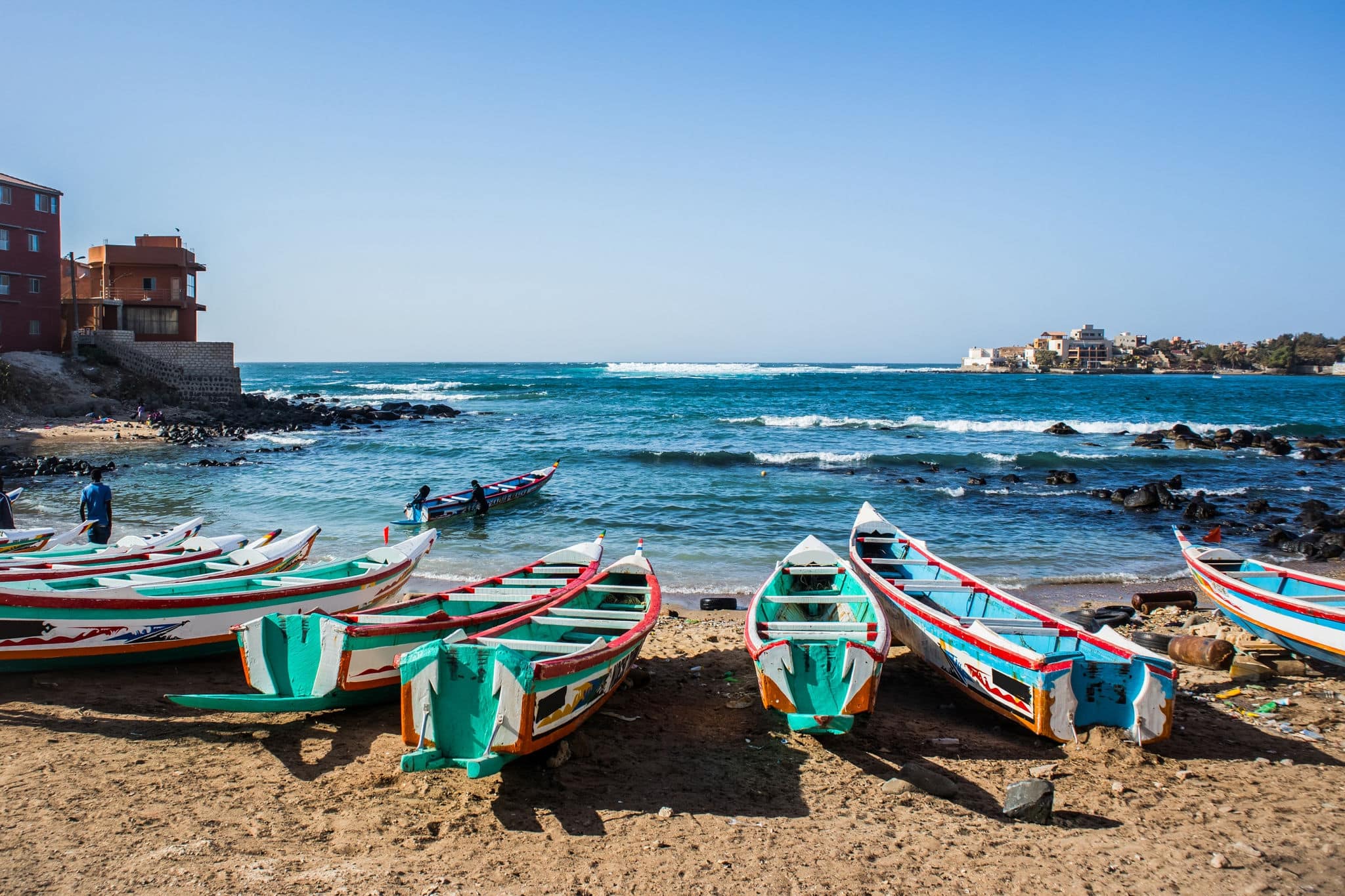 Fishing boats in Ngor Dakar, Senegal, called pirogue or piragua or piraga. Colorful boats used by fishermen standing in the bay of Ngor on a sunny day.