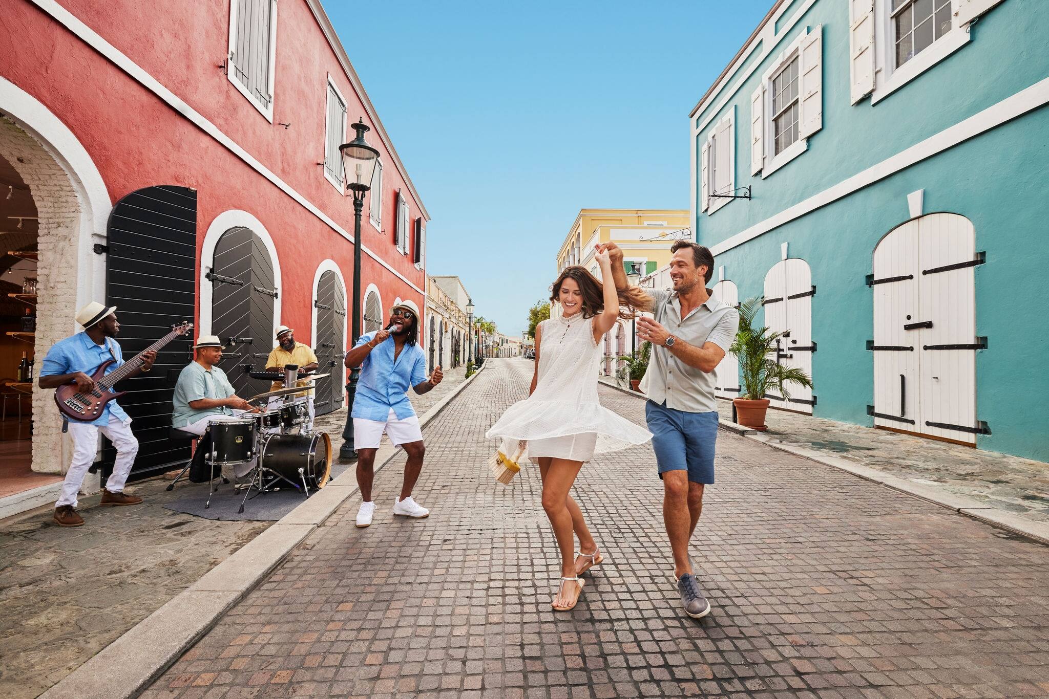 Couple dancing down colorful street. 