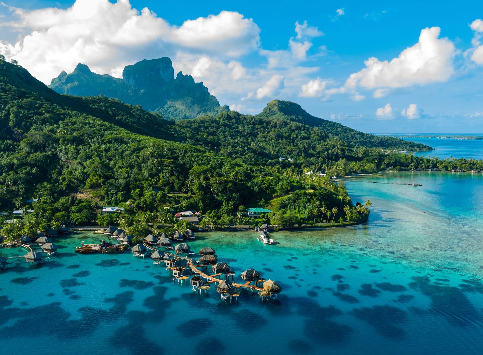 Bora Bora aerial drone video of travel vacation paradise with overwater bungalows luxury resort, coral reef lagoon ocean beach. Mount Otemanu, Bora Bora, French Polynesia, Tahiti, South Pacific Ocean