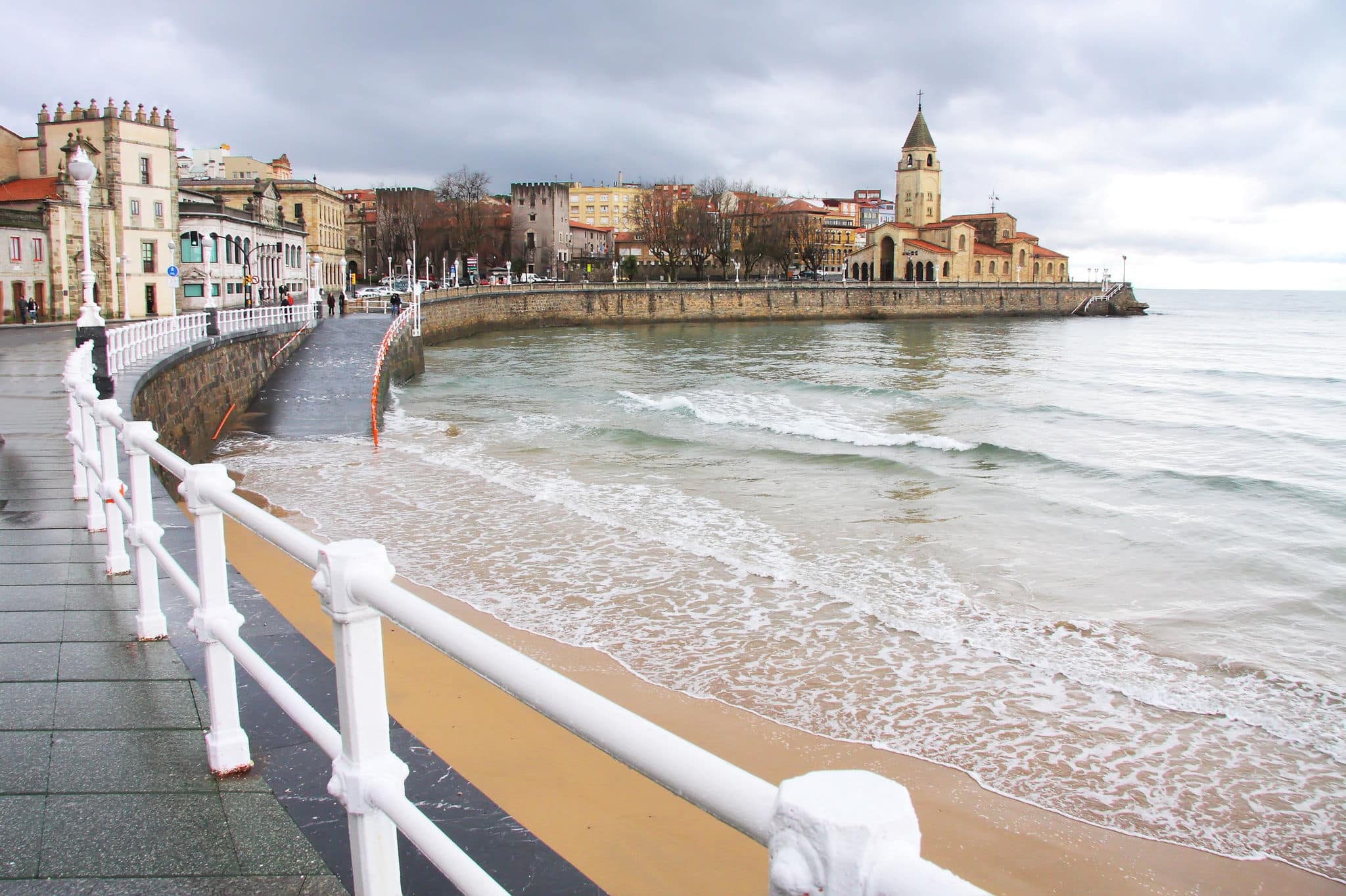 Looking along San Lorenzo's beach towards the peninsula of Santa Catalina at Gijon in Asturias, Spain.