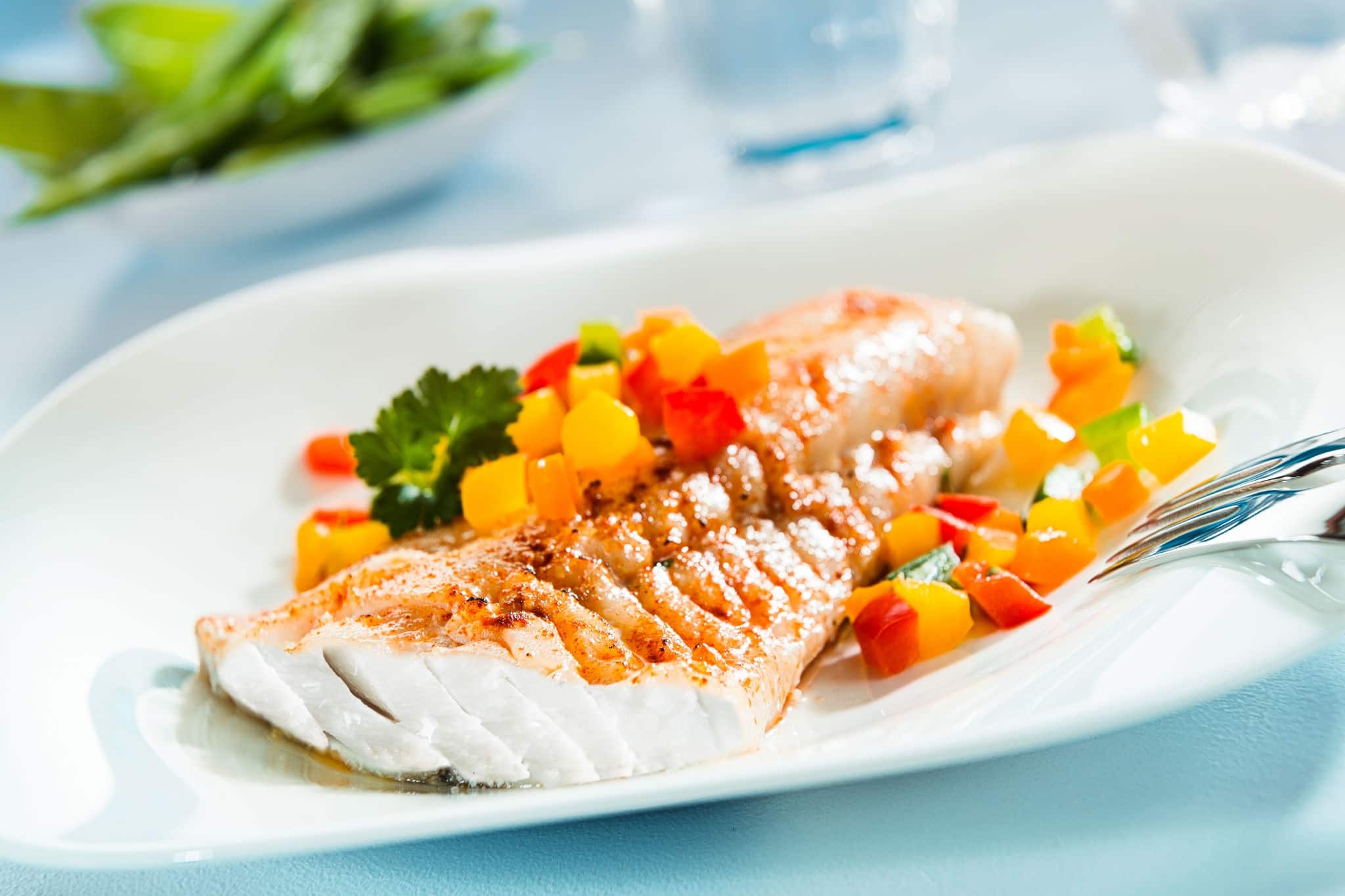 Delicious healthy grilled fish fillet served on a platter with a colorful fresh salad for a tasty seafood dinner