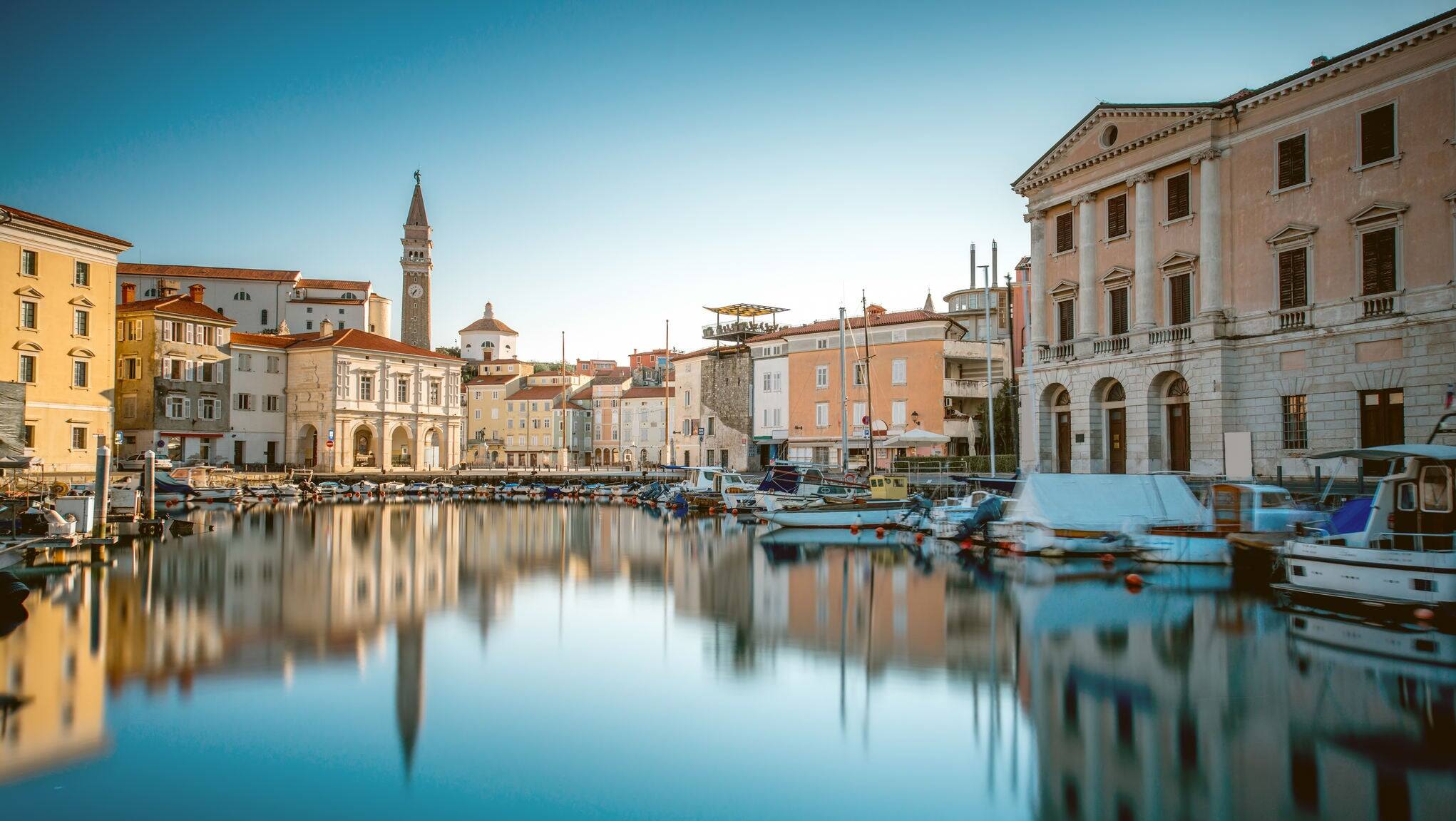 View on Piran medieval town from the bay with boats at the sunrise in Slovenia