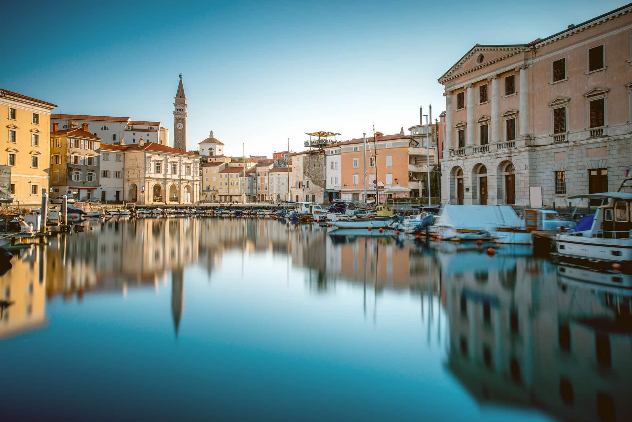 View on Piran medieval town from the bay with boats at the sunrise in Slovenia