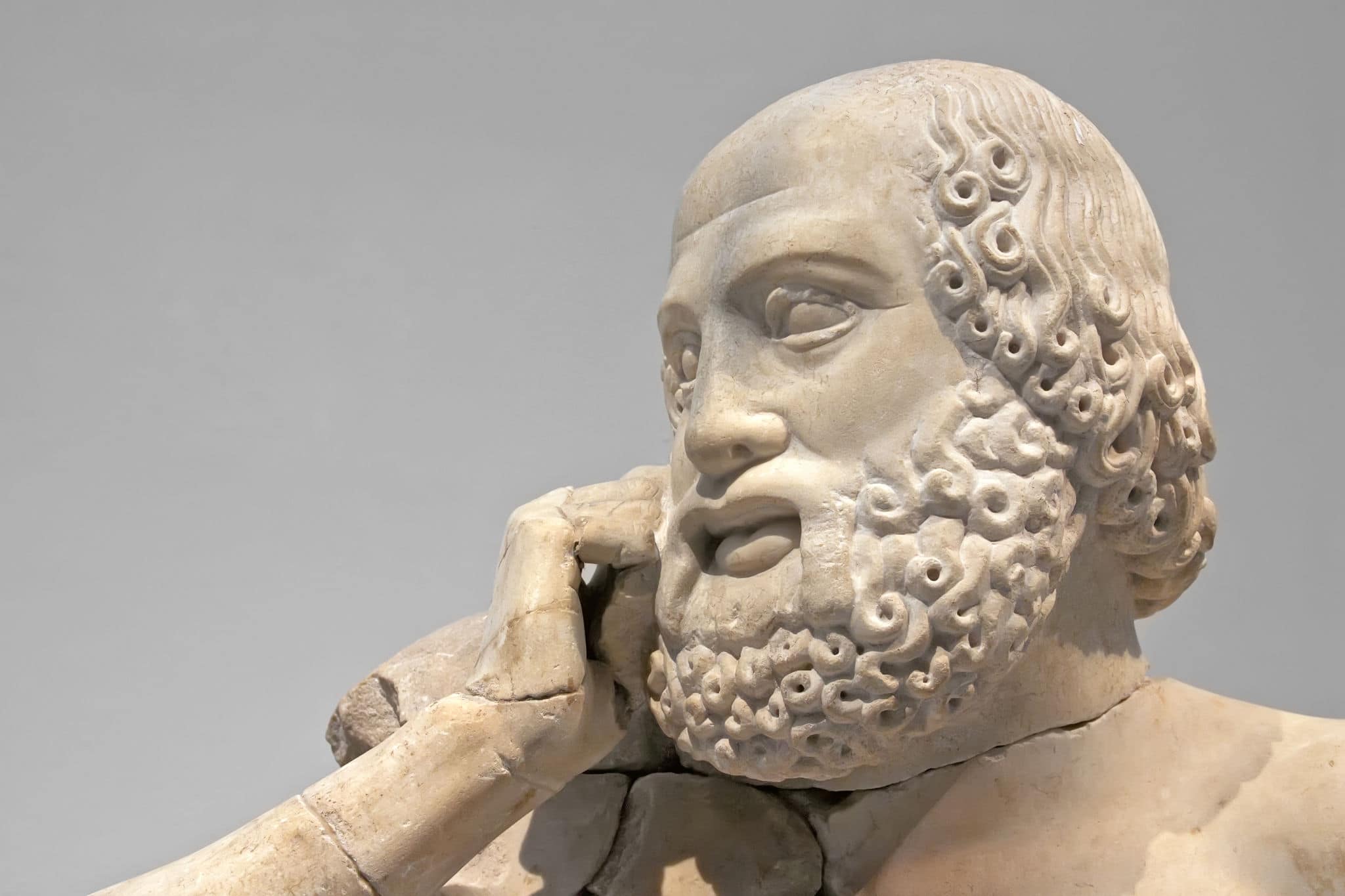 Ancient ruins of the Philippeion at Olympia, Greece. Detail of an ancient Greek statue of a human. Site of the ancient Olympic Games is situated on the Peloponnese. UNESCO world heritage site.