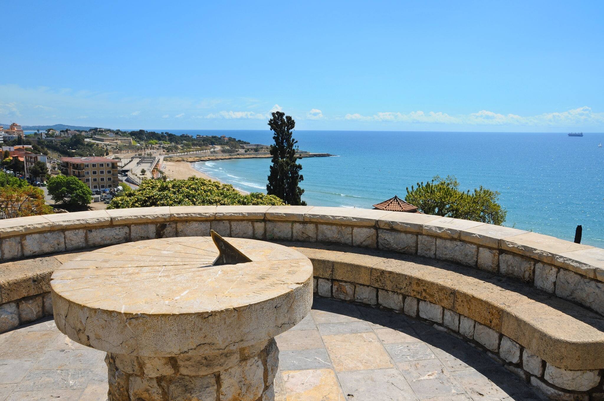 A view of a sundial and panoramic view of Tarragona coast, in Spain