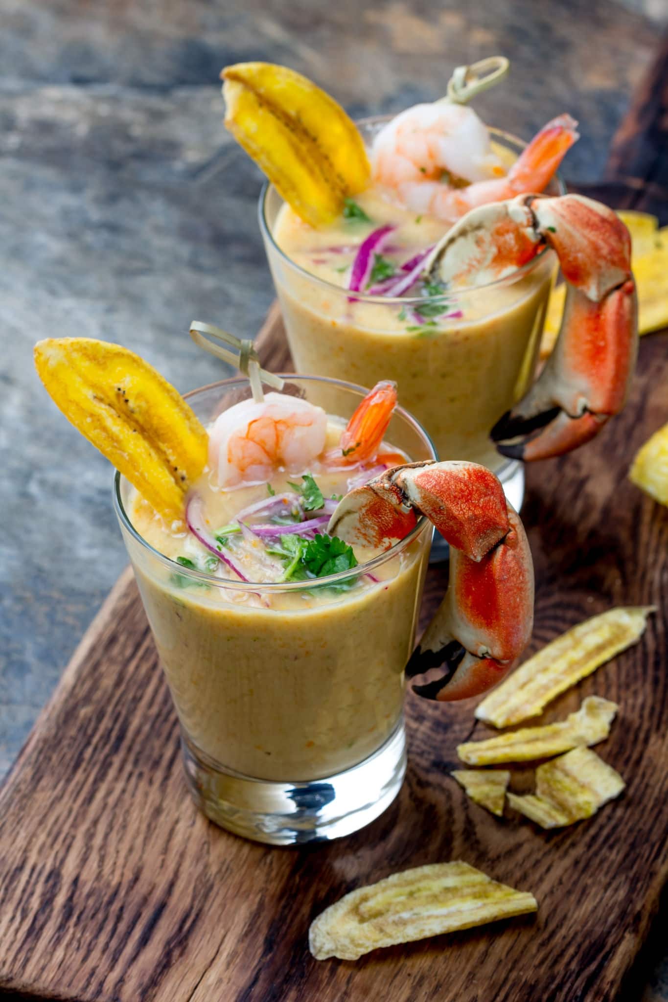Peruvian seviche LECHE DE TIGRE. Raw fish cocktail ceviche with lime, grinder, chili and cilantro. Traditional peruvian food decorated with crabs, srimps and banana chips.