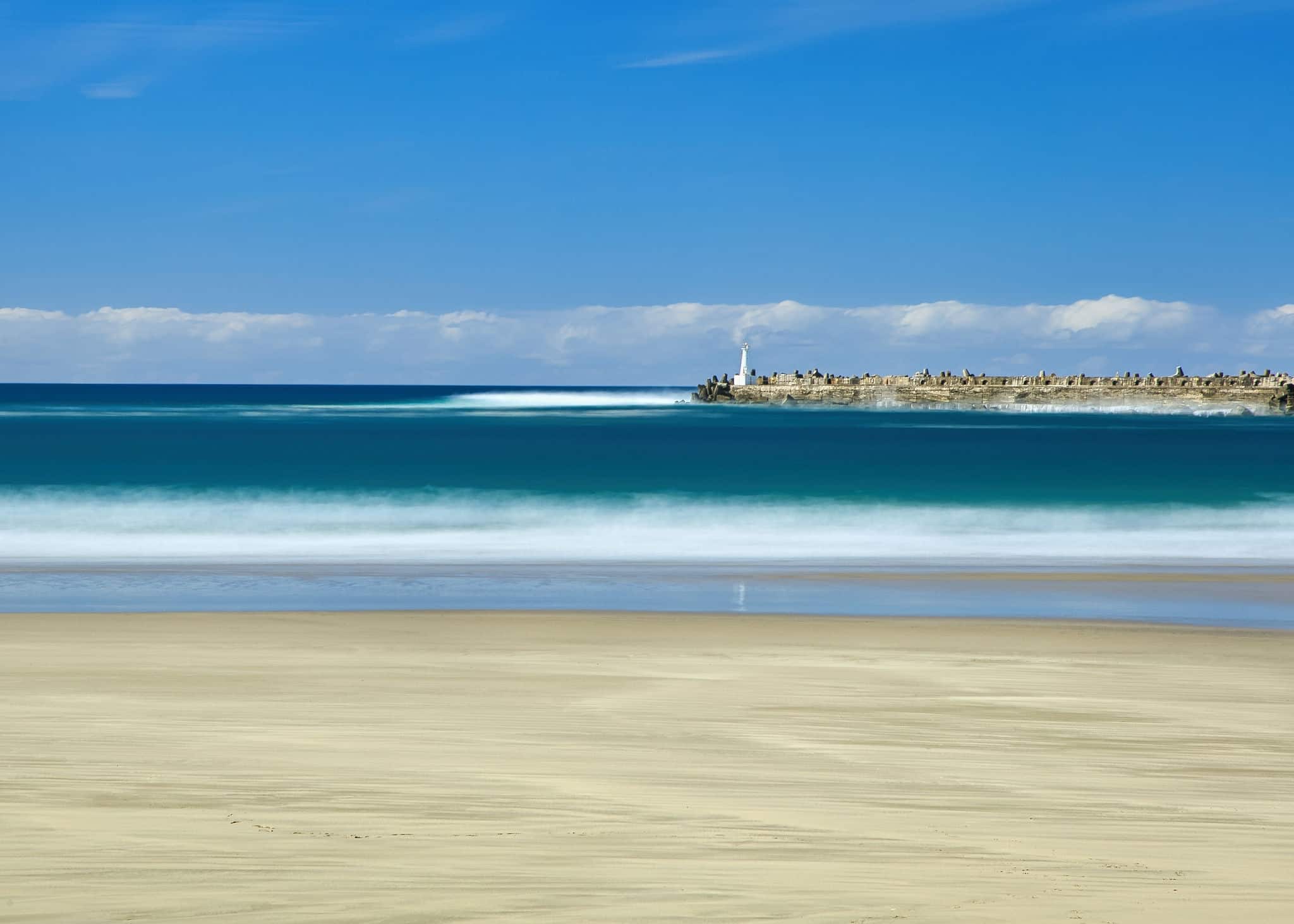 This is Orient Beach in East London, South Africa.  The Orient Pier and light beacon are visible in the background, a well-known fishing spot.
