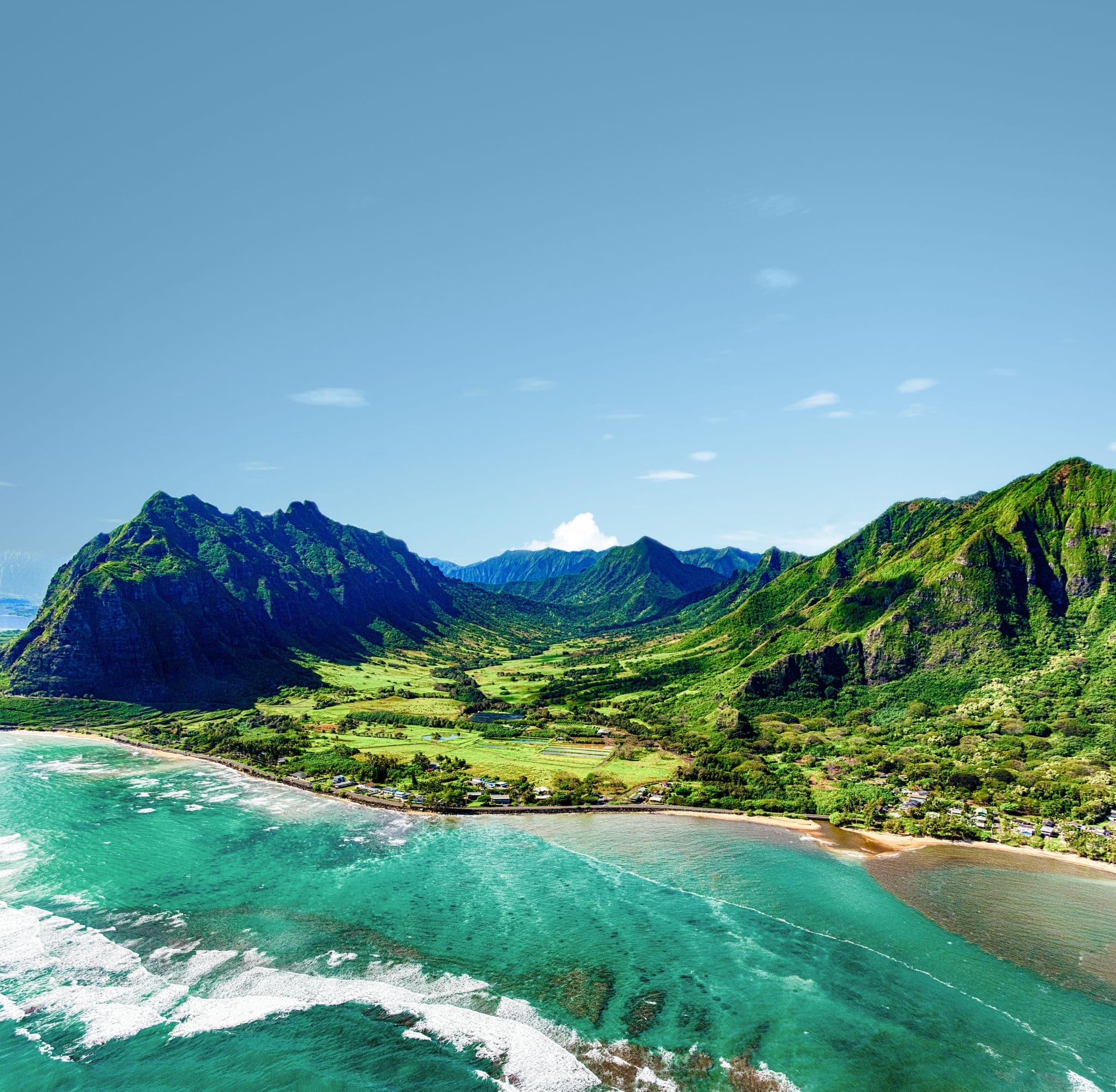 The beautiful and unique landscape of coastal Oahu, Hawaii and the Kualoa Ranch where Jurassic Park was filmed as shot from an altitude of about 1000 feet over the Pacific Ocean.