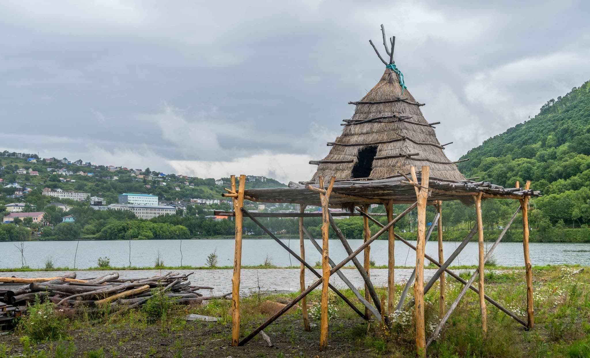 The replica of indigenous people's house and the lake surrounded by the green hills in the downtown of Petropavlovsk-Kamchatsky, the capital of Kamchatka region in Russia.