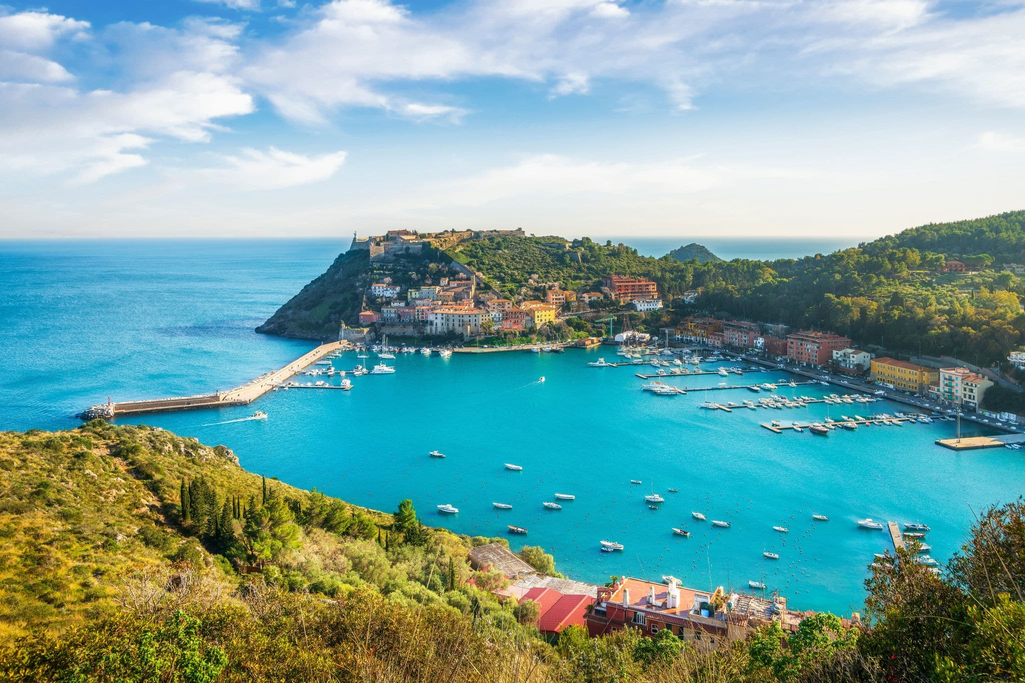 Porto Ercole village and boats in harbor in the bay. Aerial view. Monte Argentario, Maremma, province of Grosseto, Tuscany region, Italy