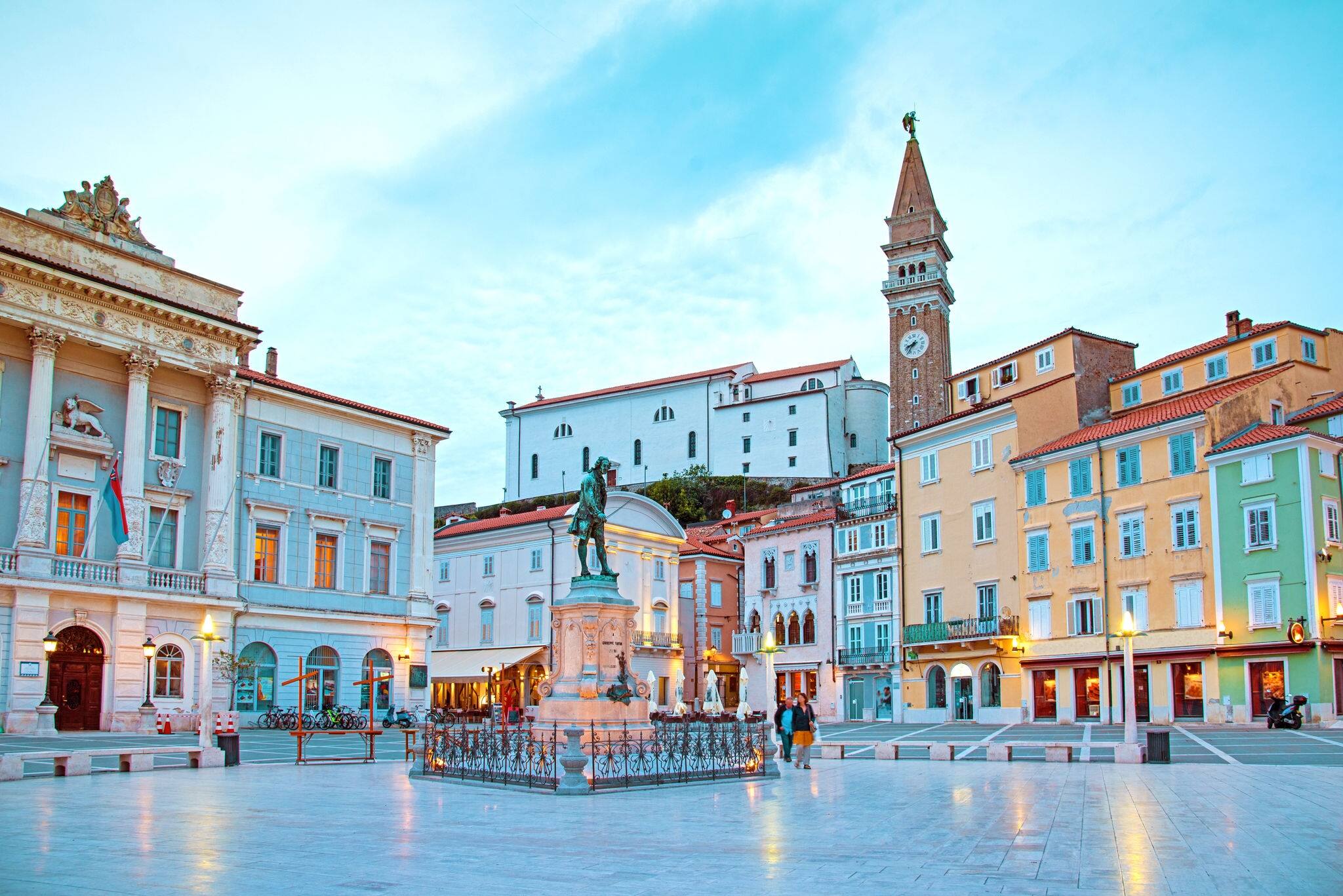 Beautiful street landscape on the central square with a monument and an ancient watch tower in Piran, the tourist center of Slovenia.