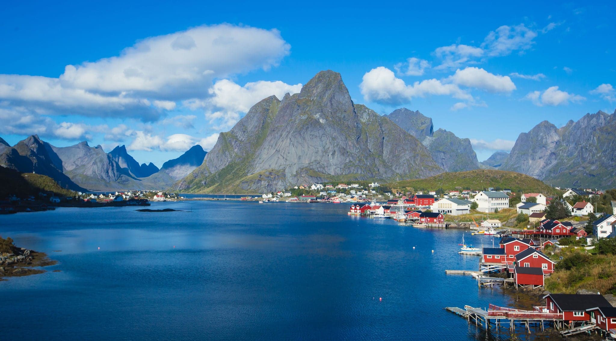 Beautiful super wide-angle summer aerial view of Reine, Norway, Lofoten Islands, with skyline, mountains, famous fishing village with red fishing cabins, Moskenesoya, Nordland