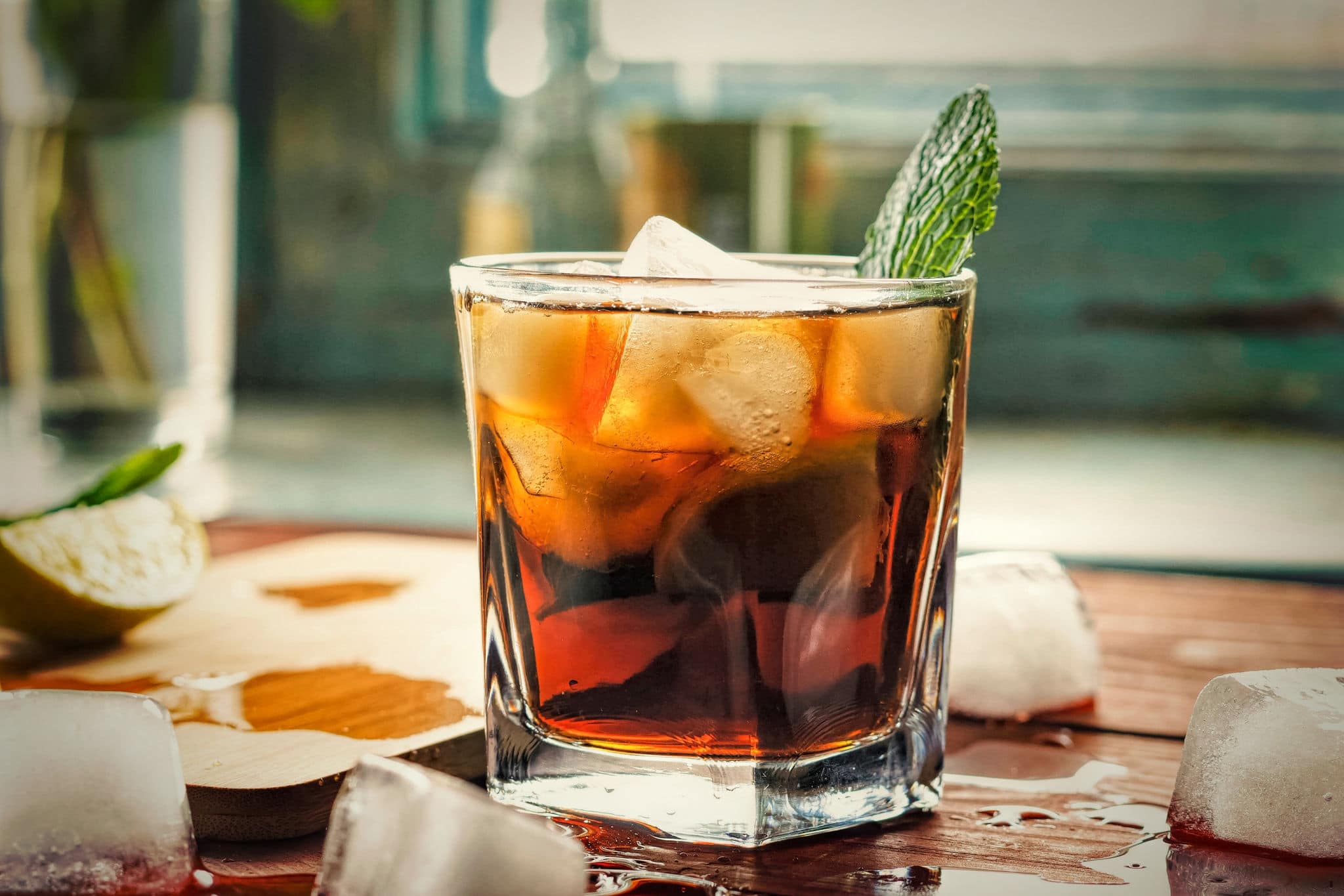 Glass of rum on the wooden background, Cuba Libre or long island iced tea cocktail with strong drinks, cola,
