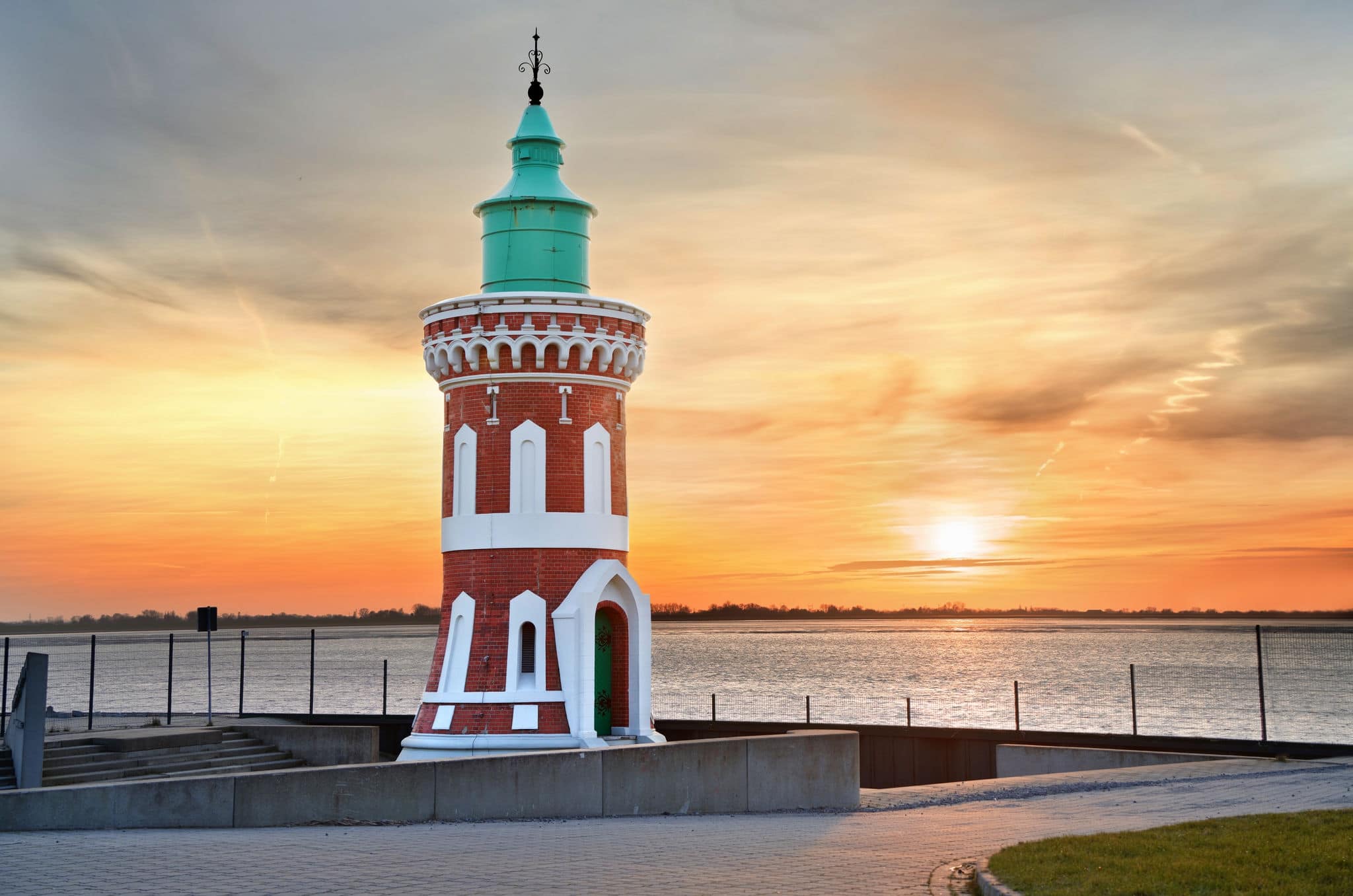kitschy sunset behind the historical lighthouse "Kaiserschleuse Ostfeuer" (Pingelturm) in Bremerhaven, Germany