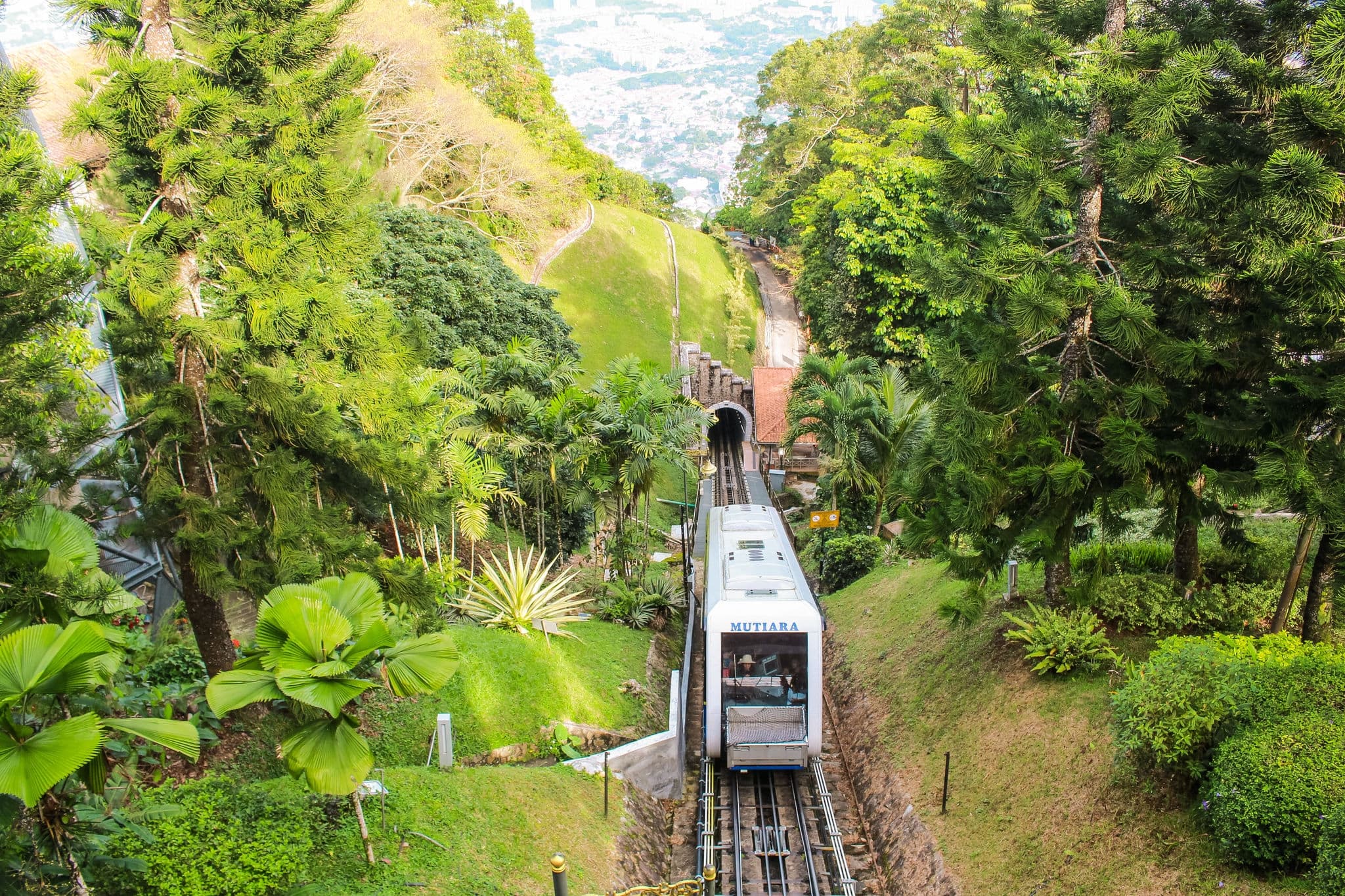 Cable car or tram uphill in Penang Hill, the most iconic transport at Penang Hill, Penang, Malaysia emerging from the tunnel and arriving at the upper station.