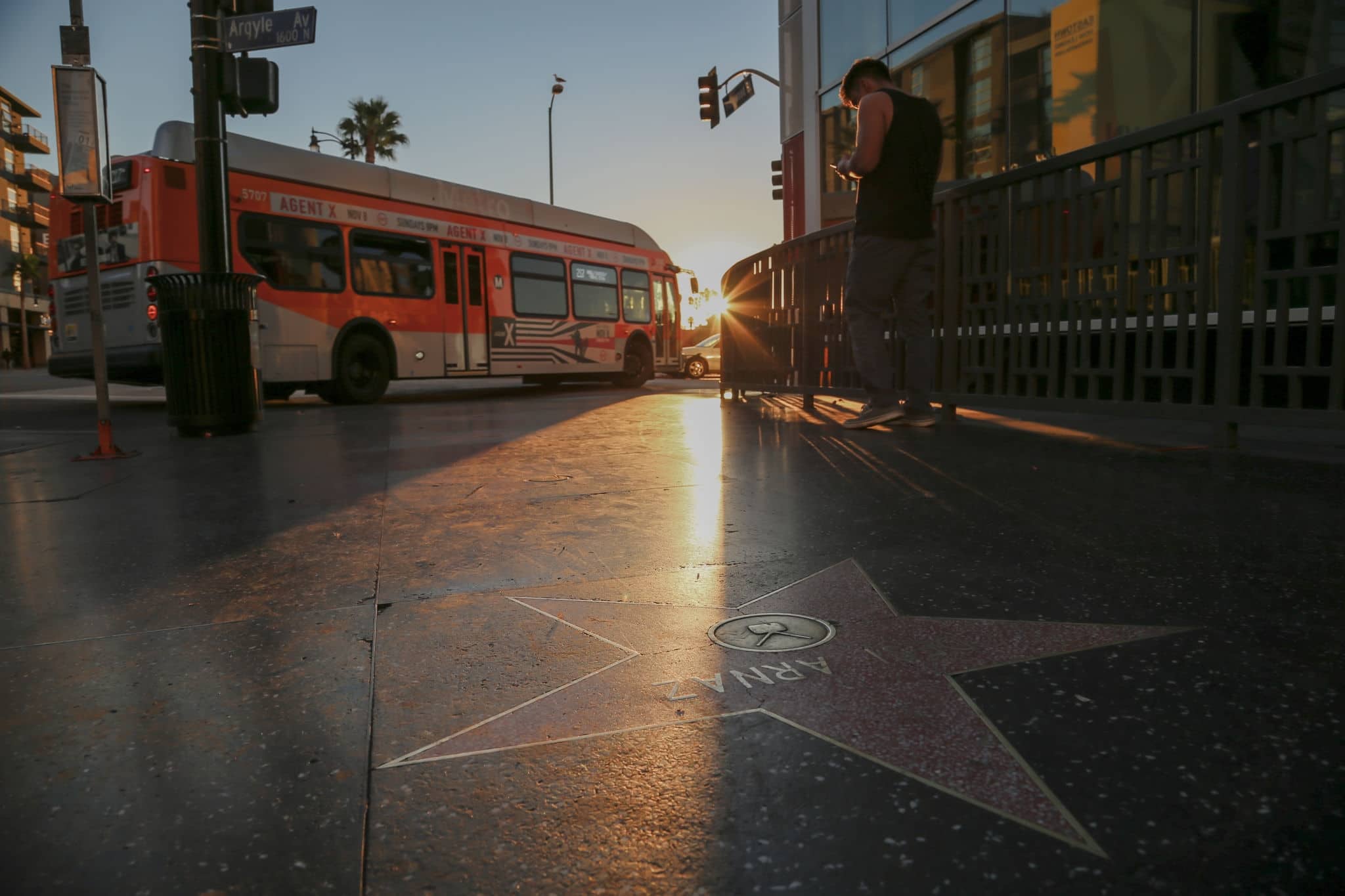 Sunrise on Hollywood Boulevard Walk of Fame as a city Bus drives by