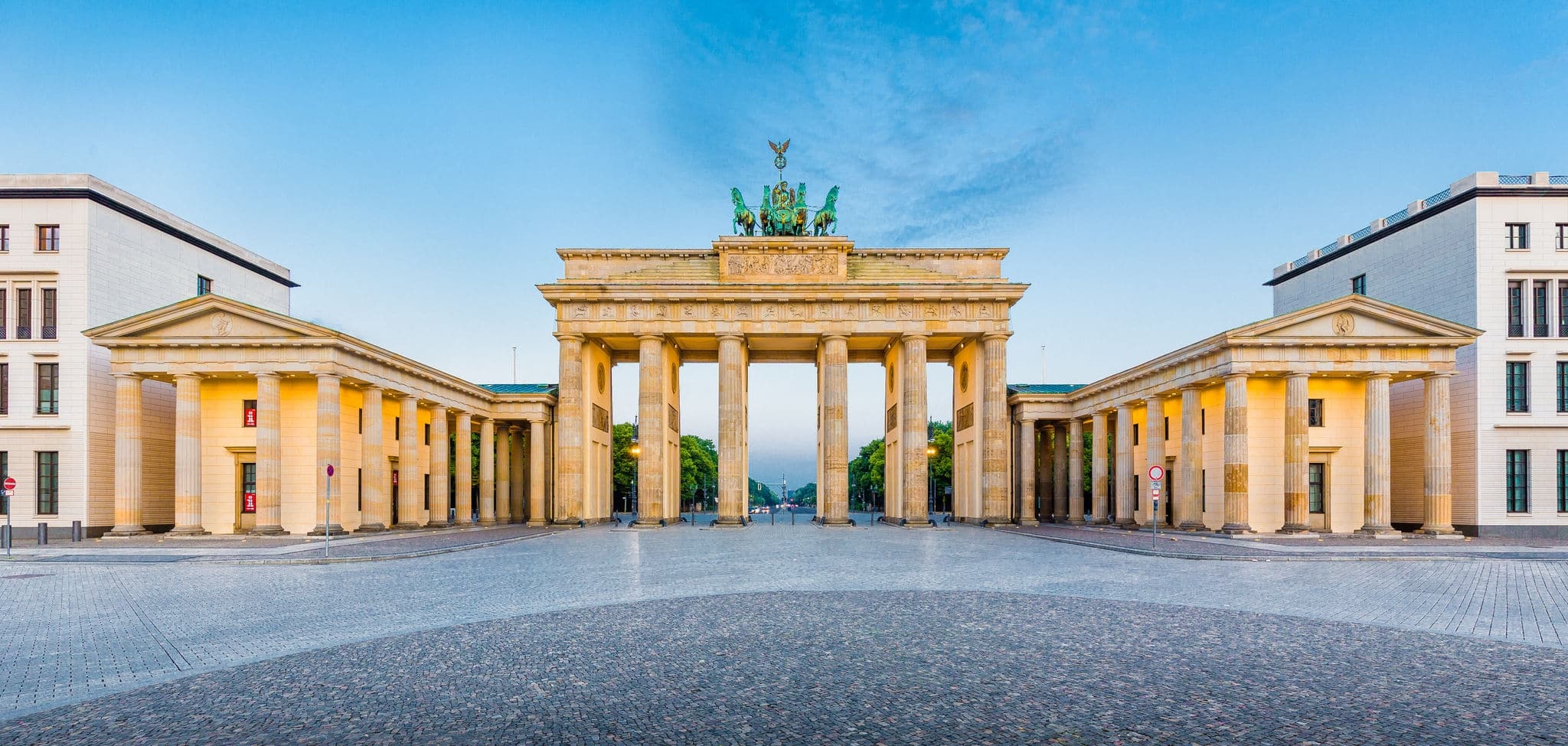 Panoramic view of famous Brandenburger Tor (Brandenburg Gate), one of the best-known landmarks and national symbols of Germany, in golden morning light at sunrise, Pariser Platz, Berlin, Germany
