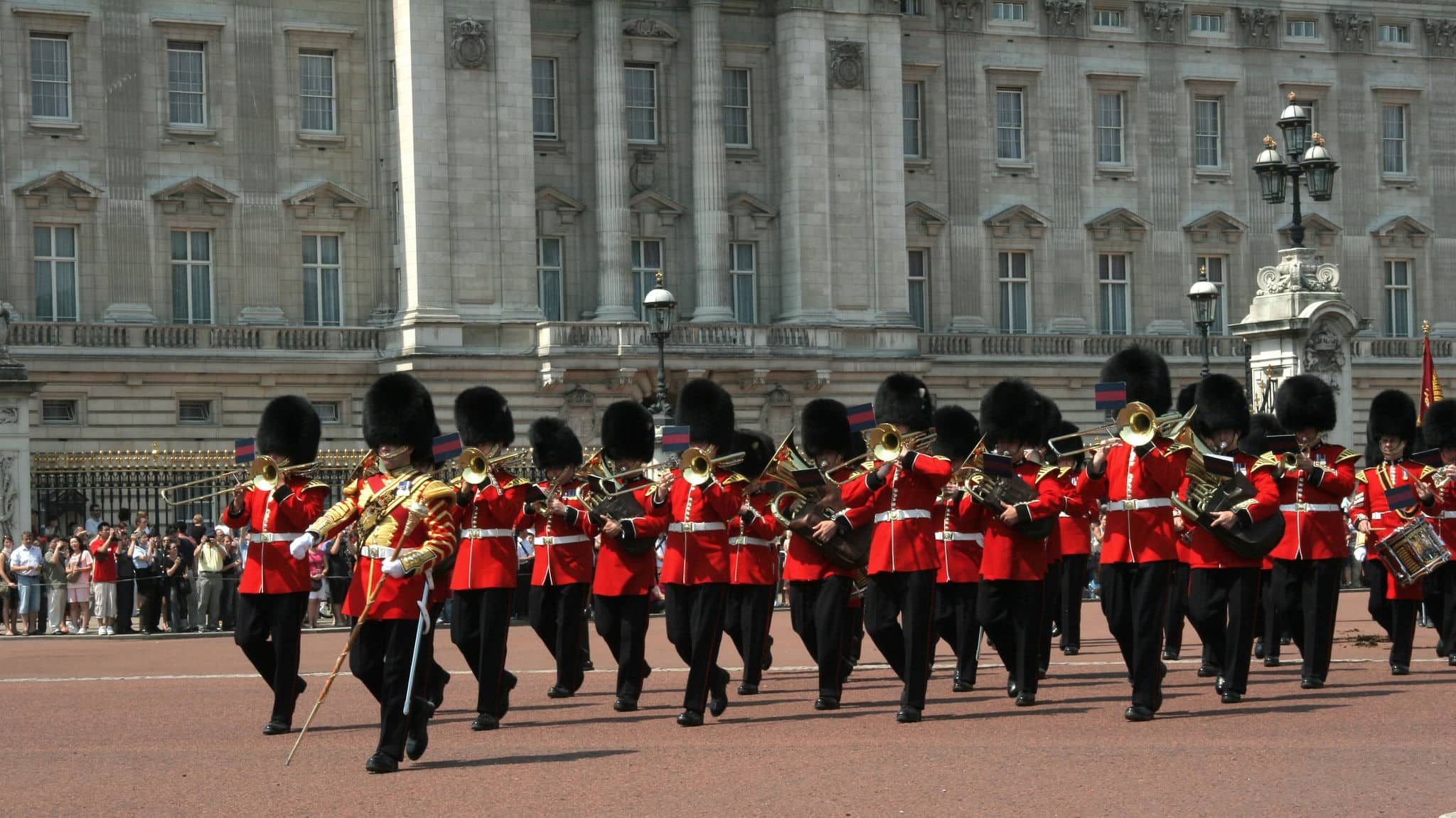 a guards band marching in front of buckingham palace