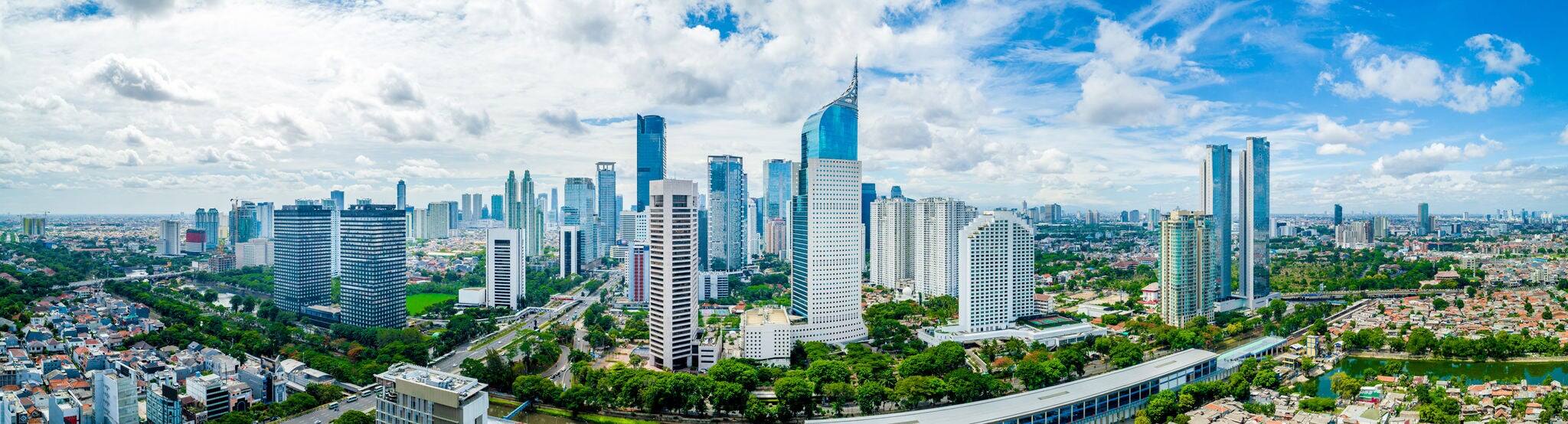 Aerial View of Jakarta Downtown Skyline with High-Rise Buildings With White Clouds and Blue Sky, Indonesia, Asia