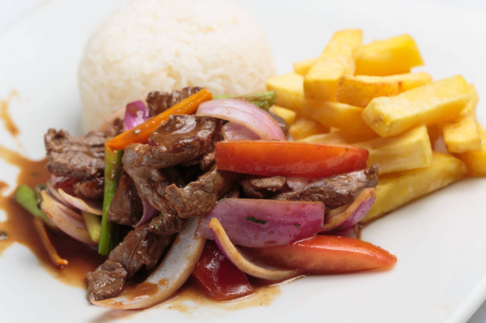 Peruvian food "lomo saltado":A salted beef with tomatoes, onion, fried potatoes and rice.