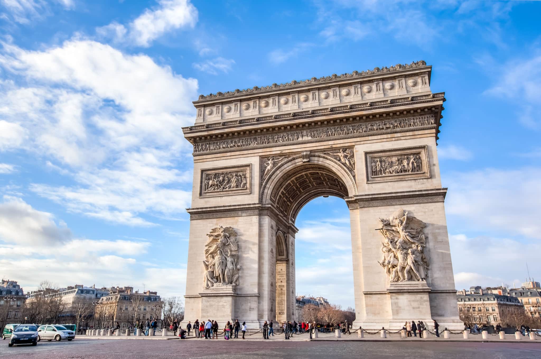 Famous Arc de Triomphe against nice blue sky  Arc de Triomphe monument at at the western end of the Champs-elysees road in Paris, France