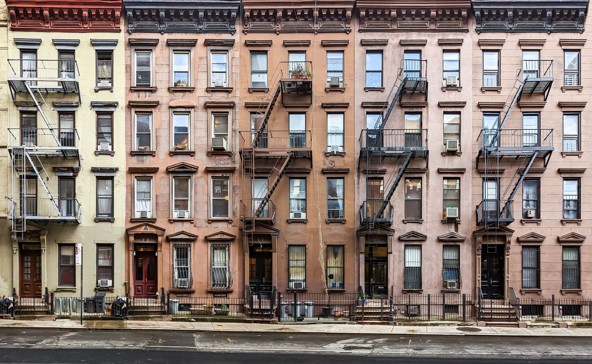 Block of historic apartment buildings crowded together on West 49th Street in the Hell's Kitchen neighborhood of New York City NYC