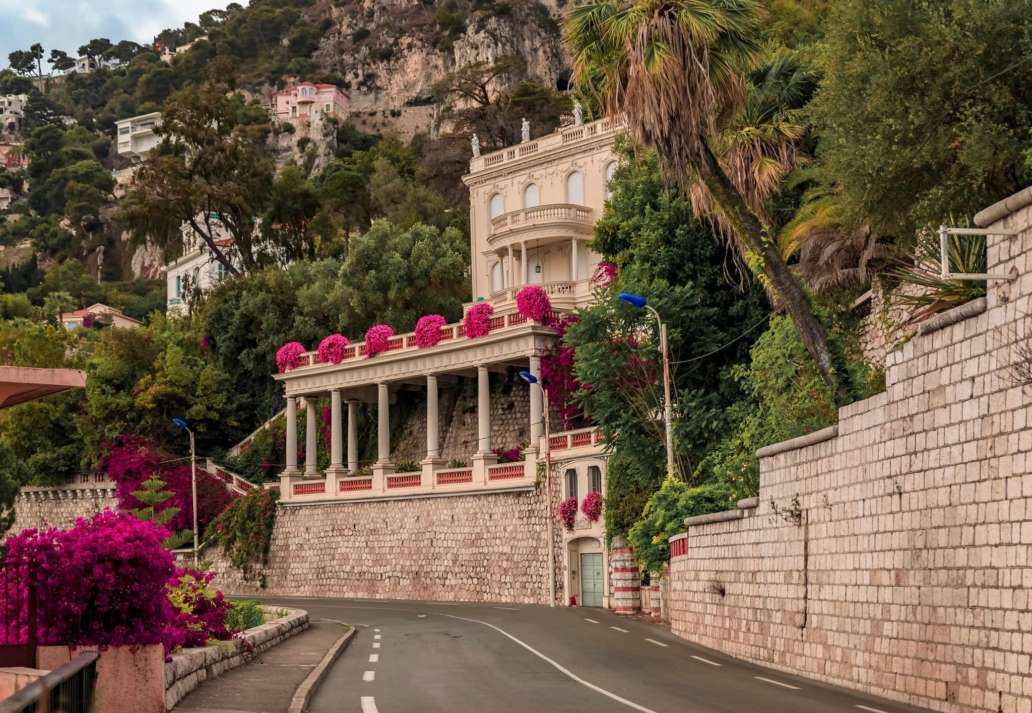 Bougainvillea blossom framing a coastal road on the French Riviera in picturesque medieval seaside Villefranche sur Mer, South of France