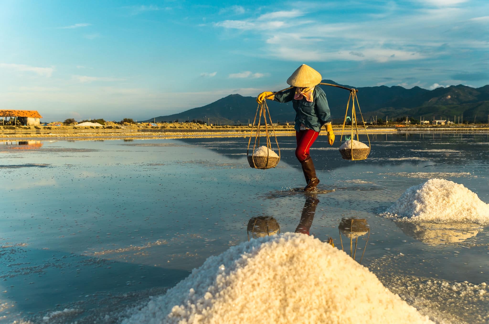 Nha Trang, Vietnam. Women carry salt from salt farm to factory.