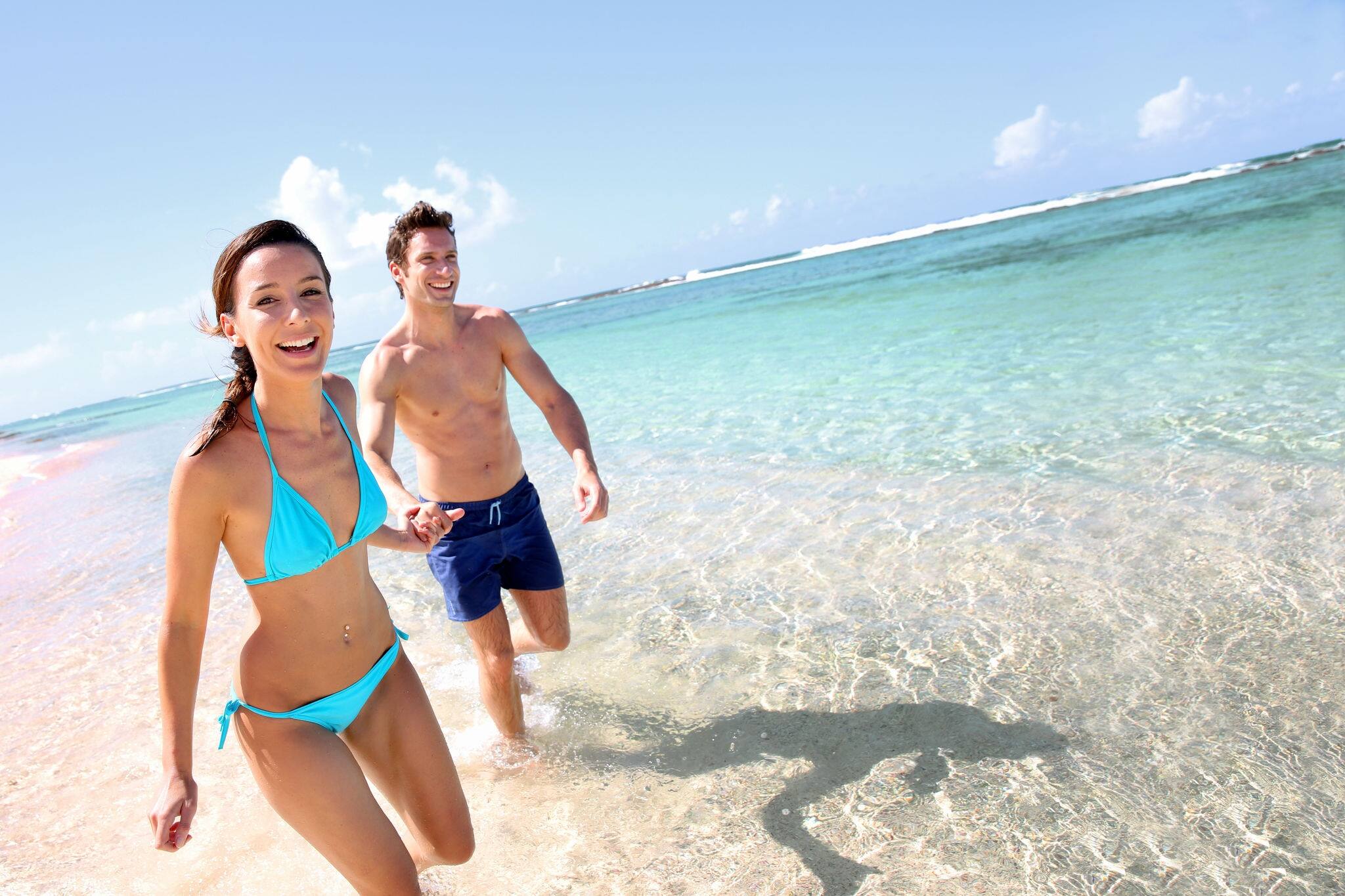 Couple running on a sandy beach. 