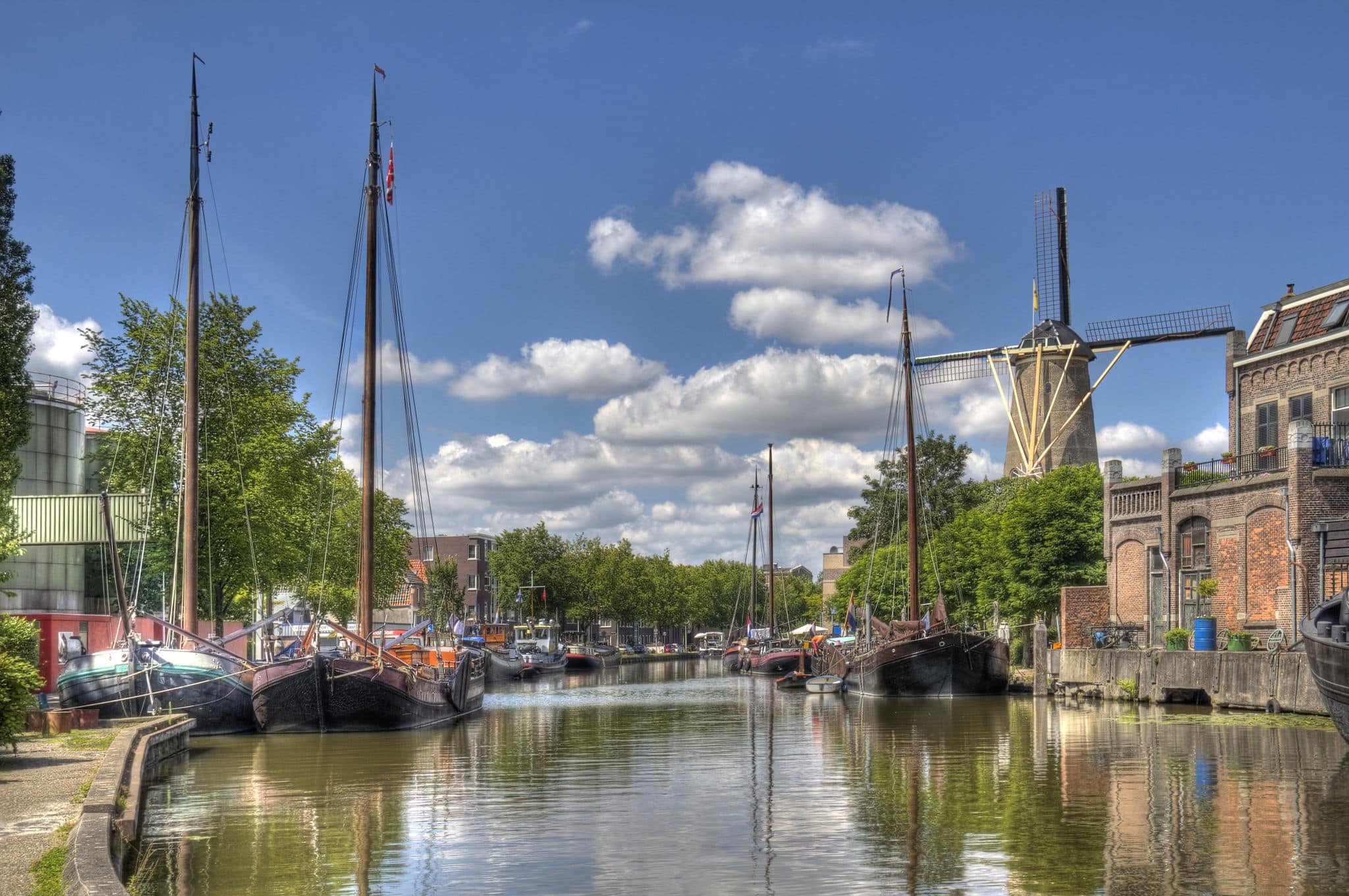 Windmill and historical boats in a canal in Gouda, Holland