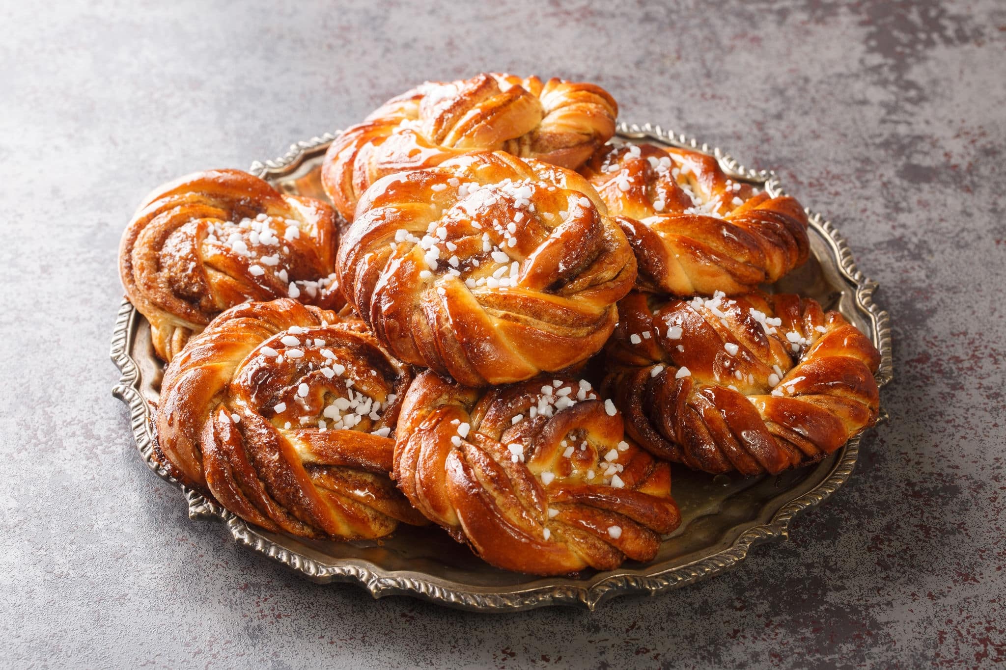 Homemade tasty Kanelbulle the nordic cinnamon rolls close-up on a plate on the table. Horizontal