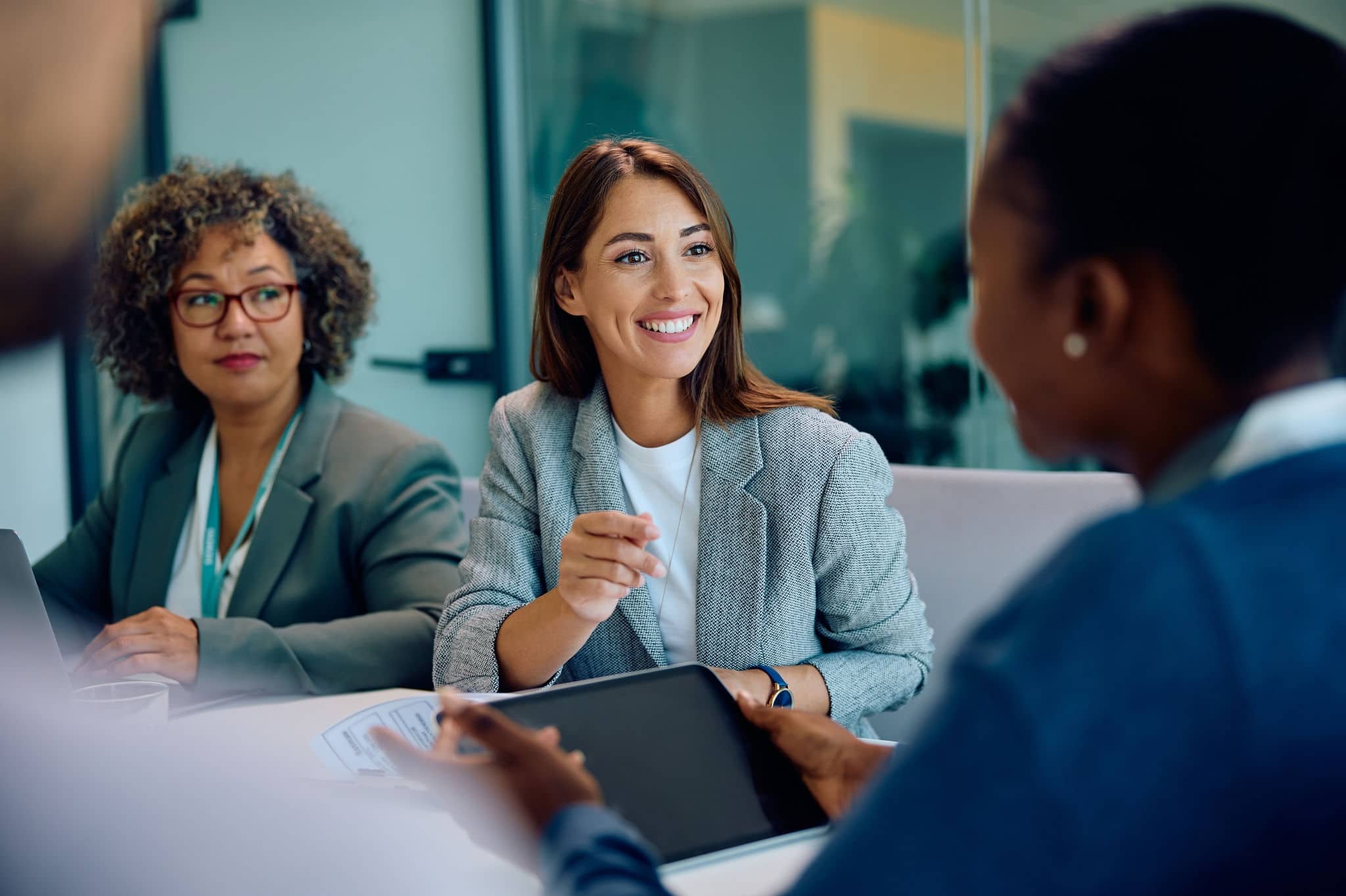 Happy female entrepreneur communicating with coworkers on a meeting in the office.