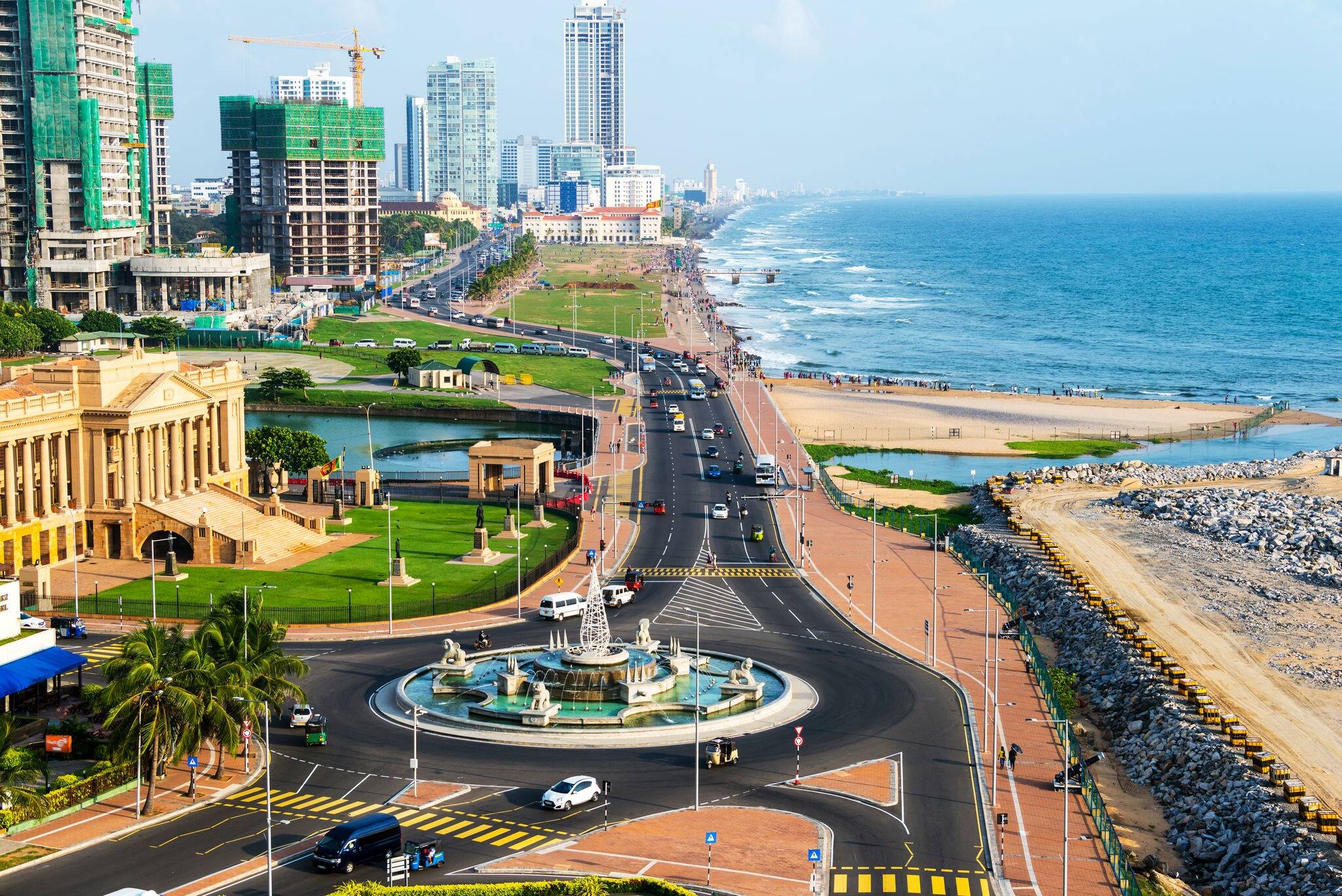 Aerial view of Colombo, Sri Lanka modern buildings with coastal promenade area. Car traffic during the day. Ocean waves