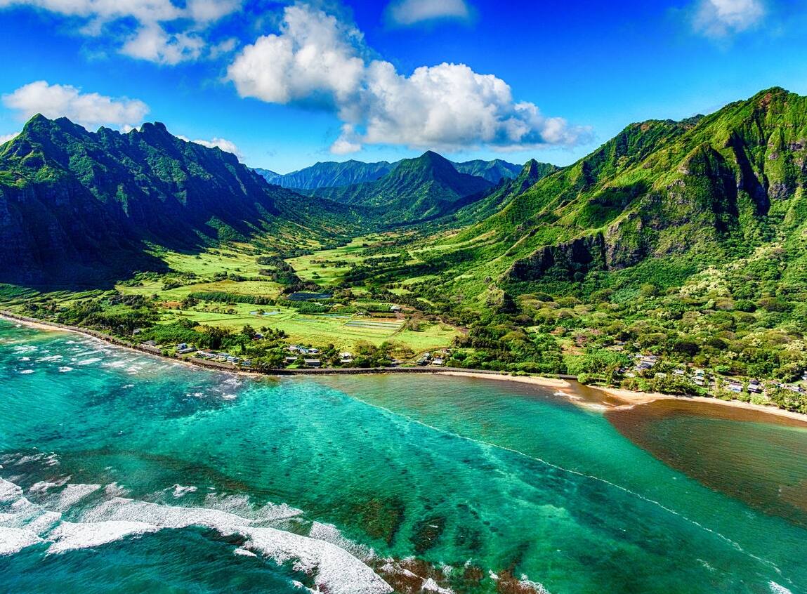 The beautiful and unique landscape of coastal Oahu, Hawaii and the Kualoa Ranch where Jurassic Park was filmed as shot from an altitude of about 1000 feet over the Pacific Ocean.