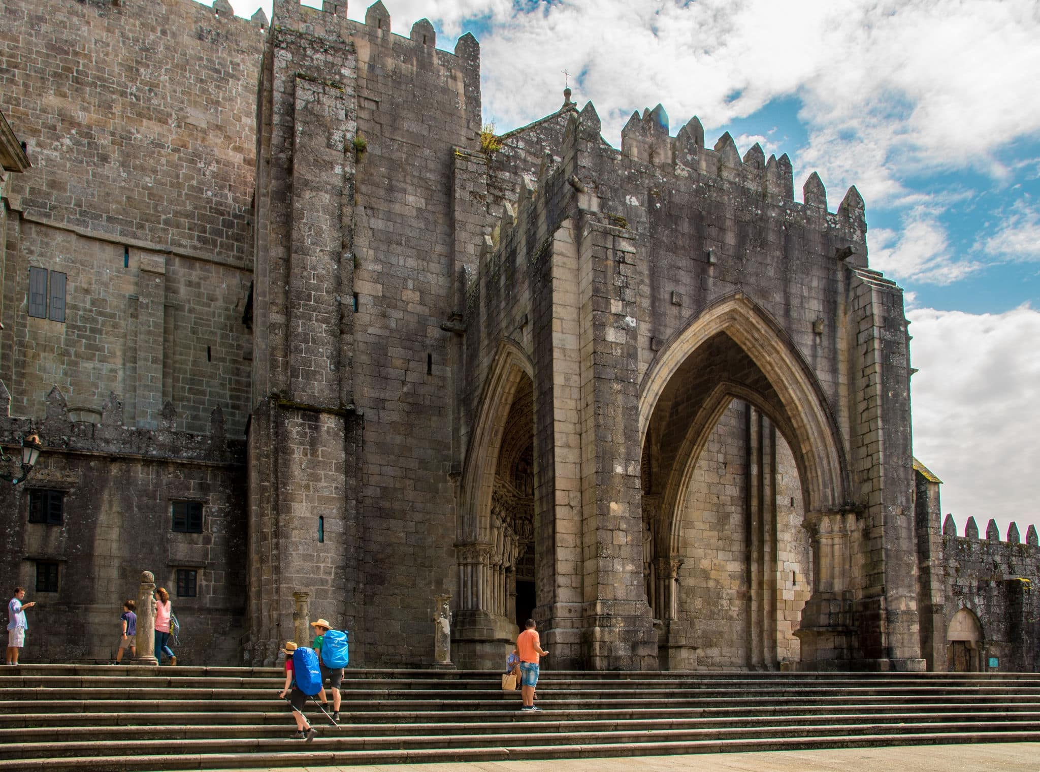 TUI, SPAIN - AUGUST 24, 2016: Cathedral of Saint Mary of Tui (11th-13th Century), Galicia, Spain. Backpackers pilgrims of The St. James Way pass by Tui town.