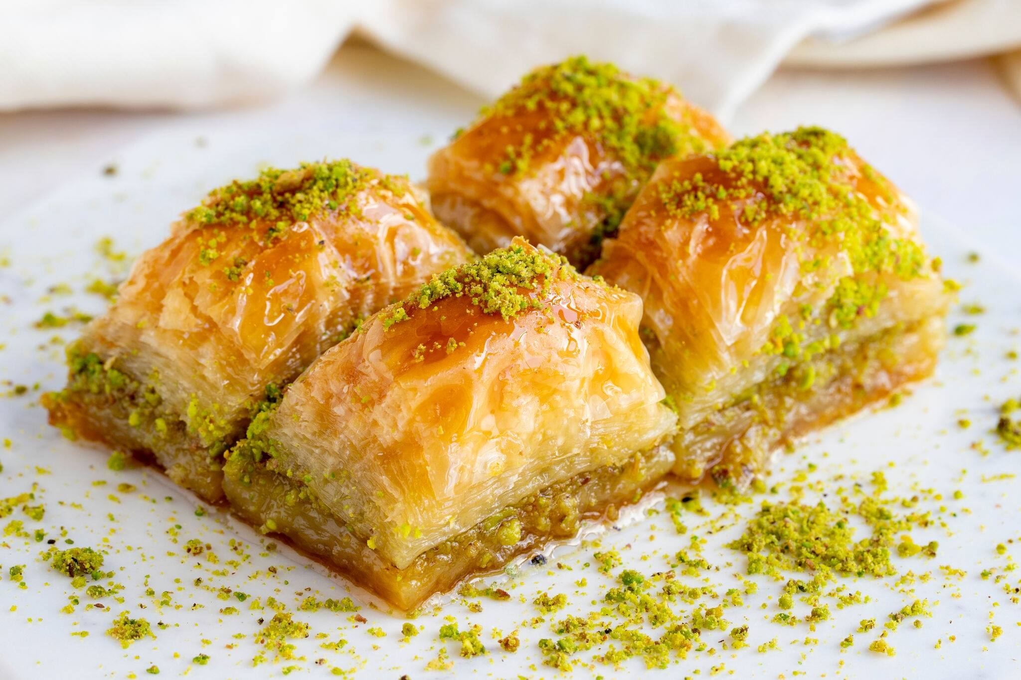 Pistachio baklava on a white wooden background. Baklava on a marble floor. Close up