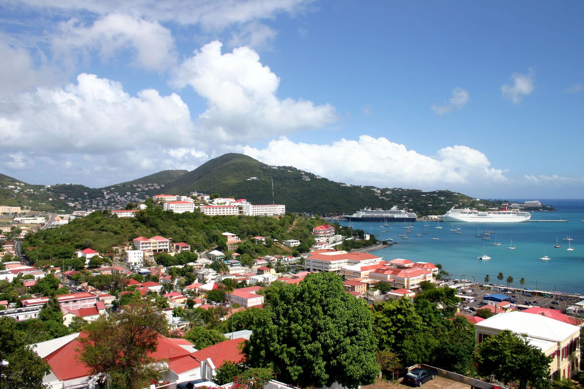 A pair of cruise ships are docked at the port in St Thomas in the Caribbean on a beautiful sunny day.