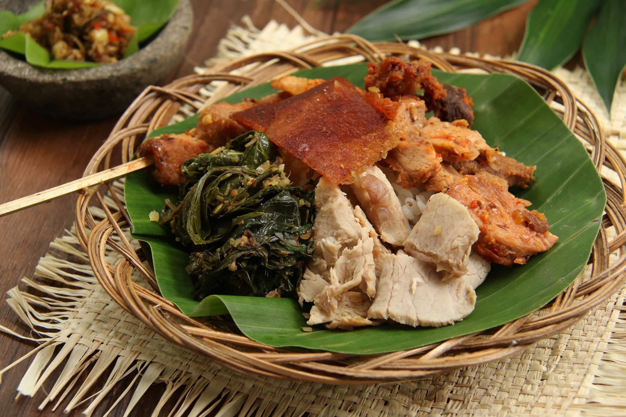 Nasi Campur Babi Guling. Balinese rice dish of roast pork dishes, vegetable served on steamed rice.