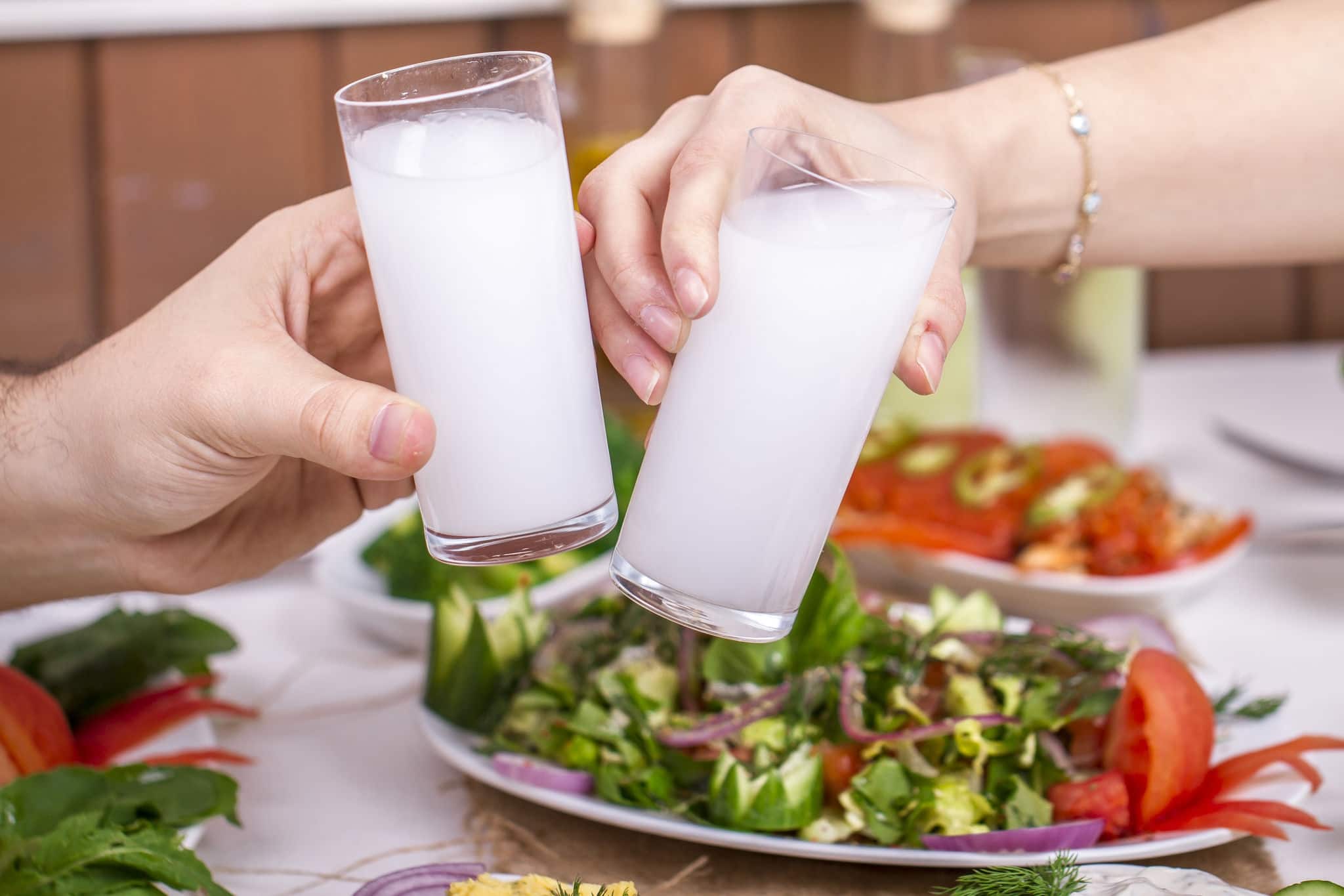 Lovely Couple Sitting, Drinking, Say Cheers and  drinking Turkish Traditional Drink Raki, Ouzo