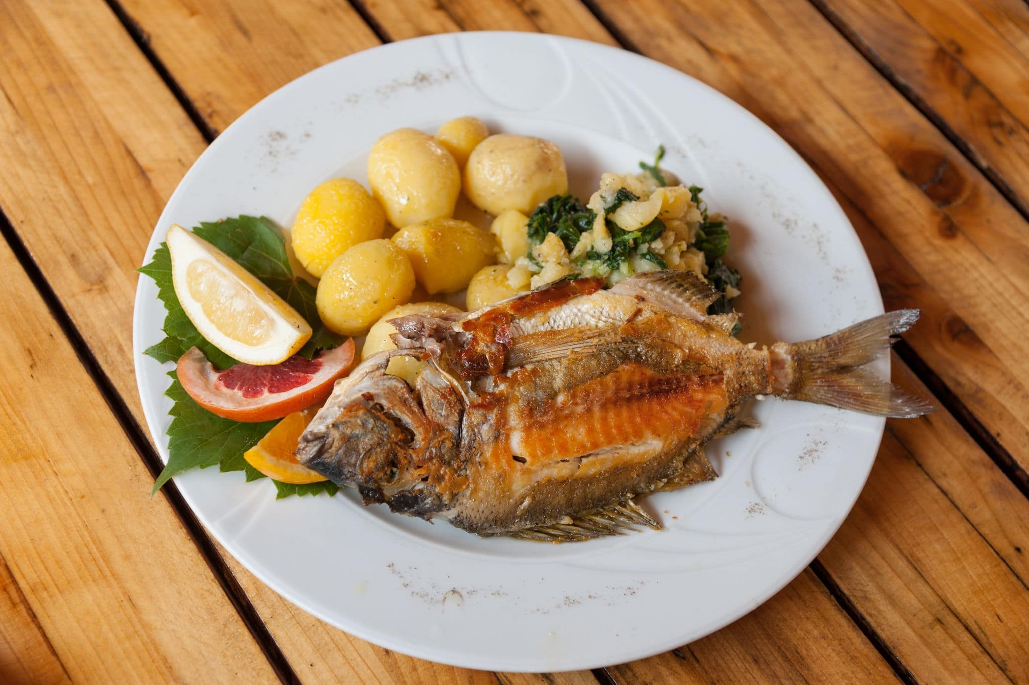 A traditional plate of grilled fish and sides in Croatian restaurant