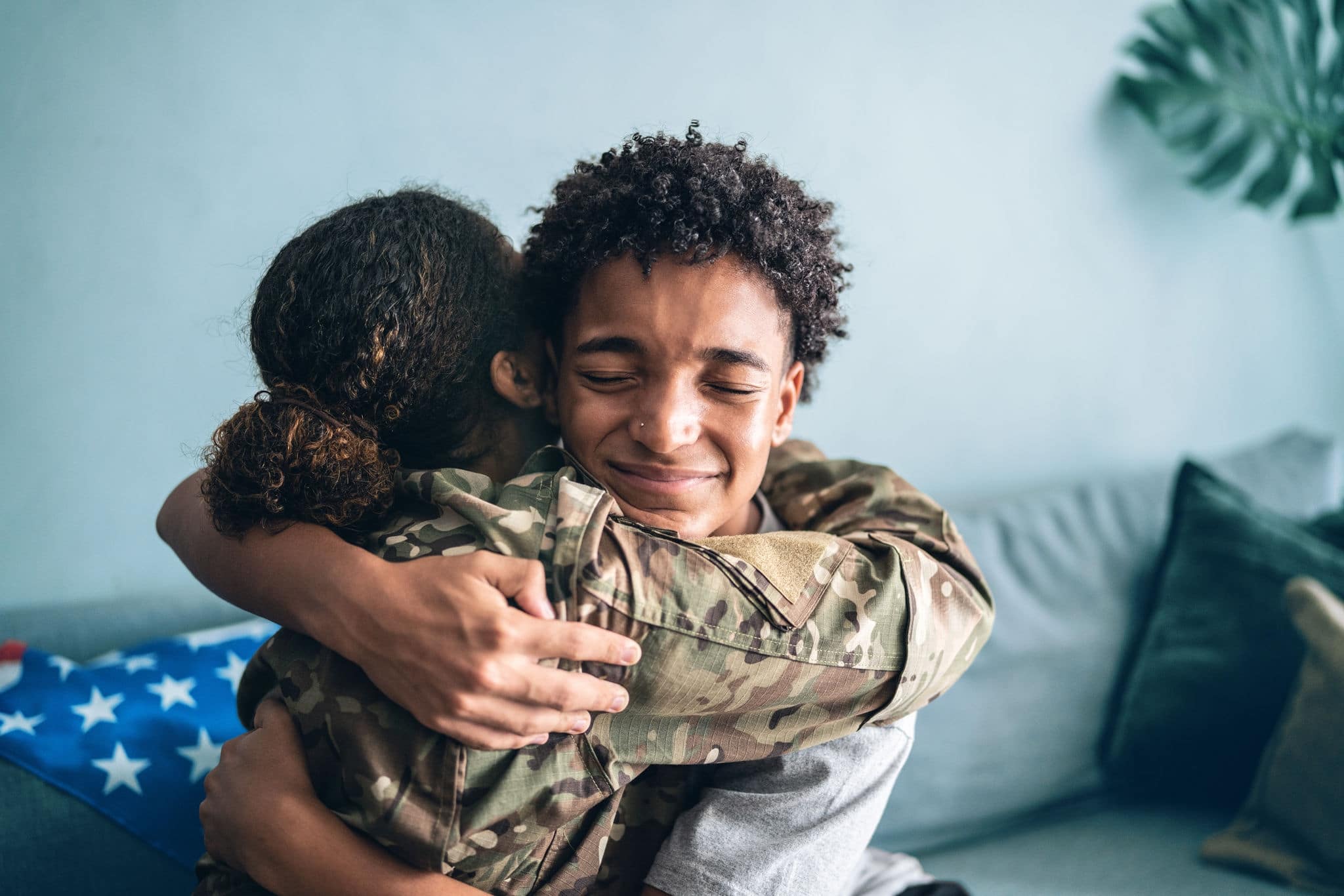 Soldier mother and son hugging each other at home